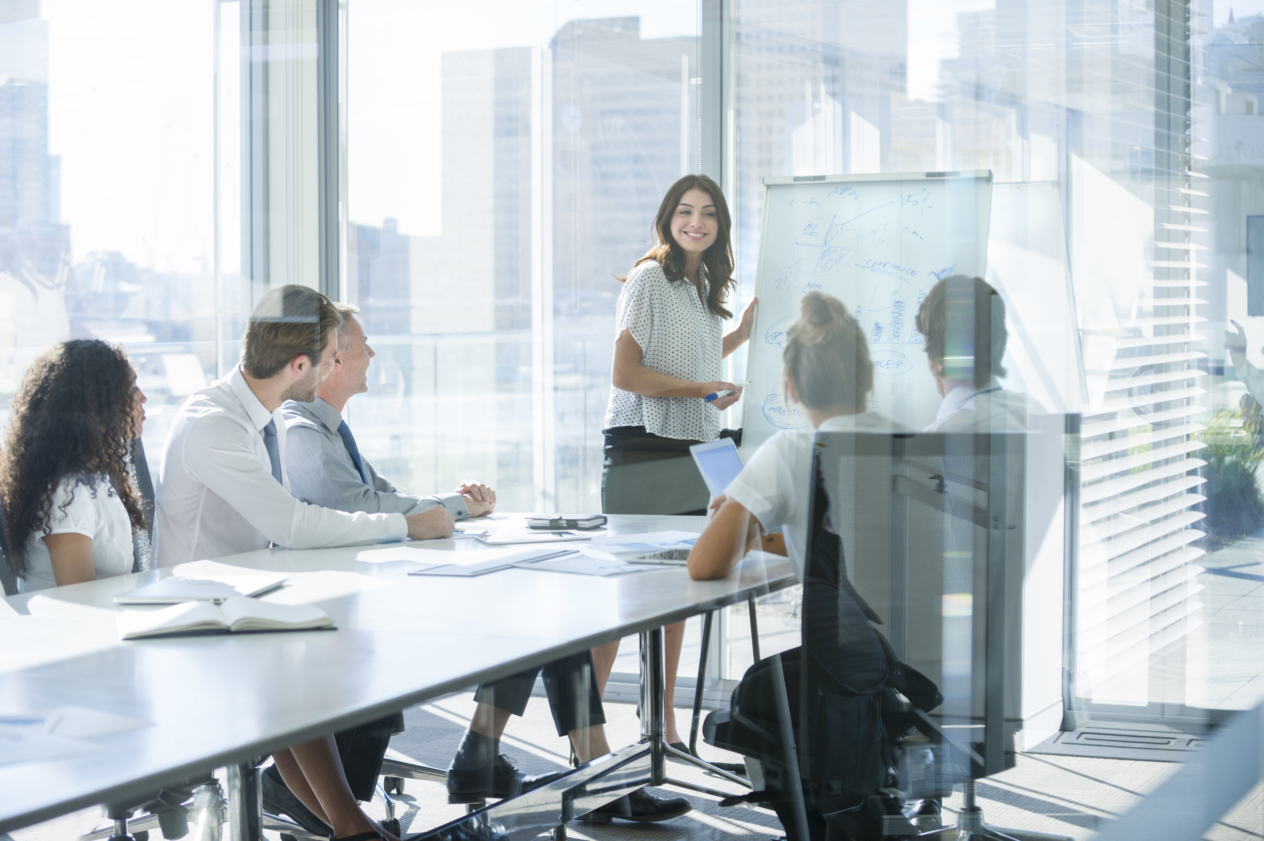 Woman-giving-a-presentation-to-her-team.-839628678_4933x3283.jpeg
