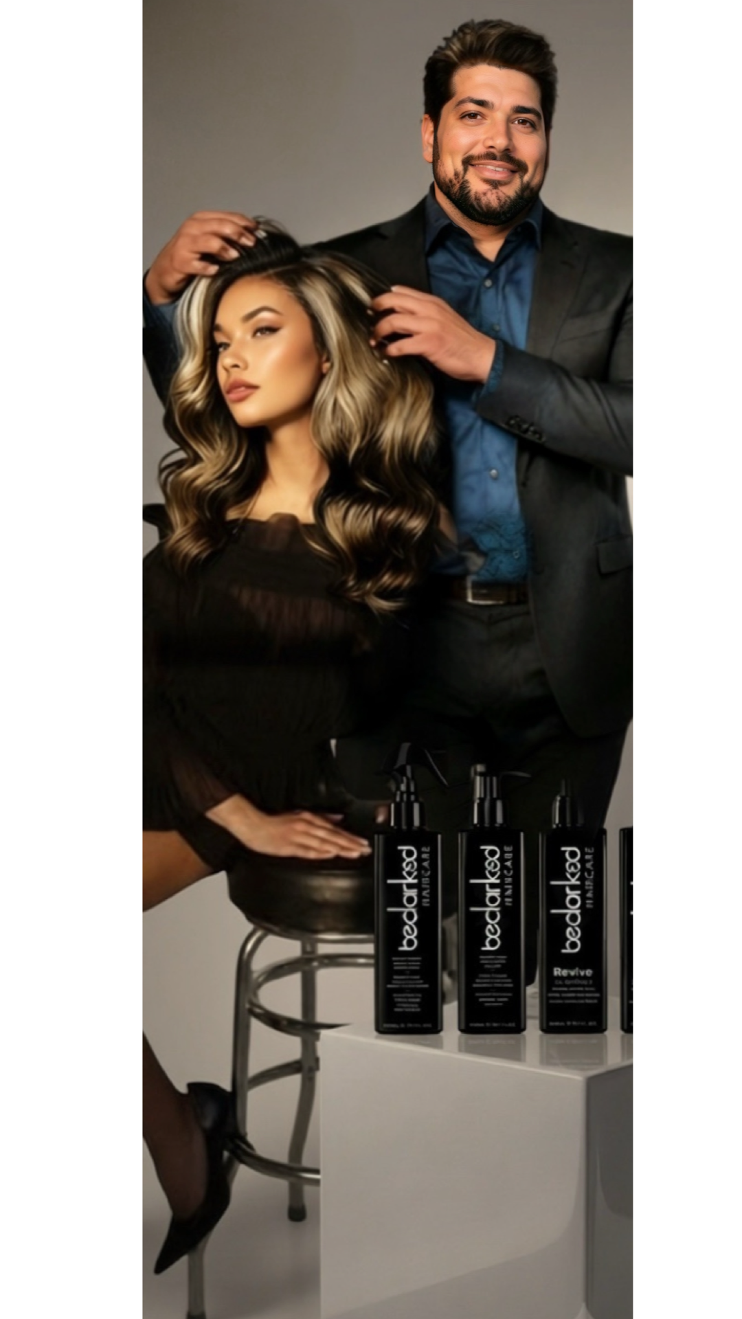 Man and woman with styled hair posing for a photo behind products labeled bedHead.