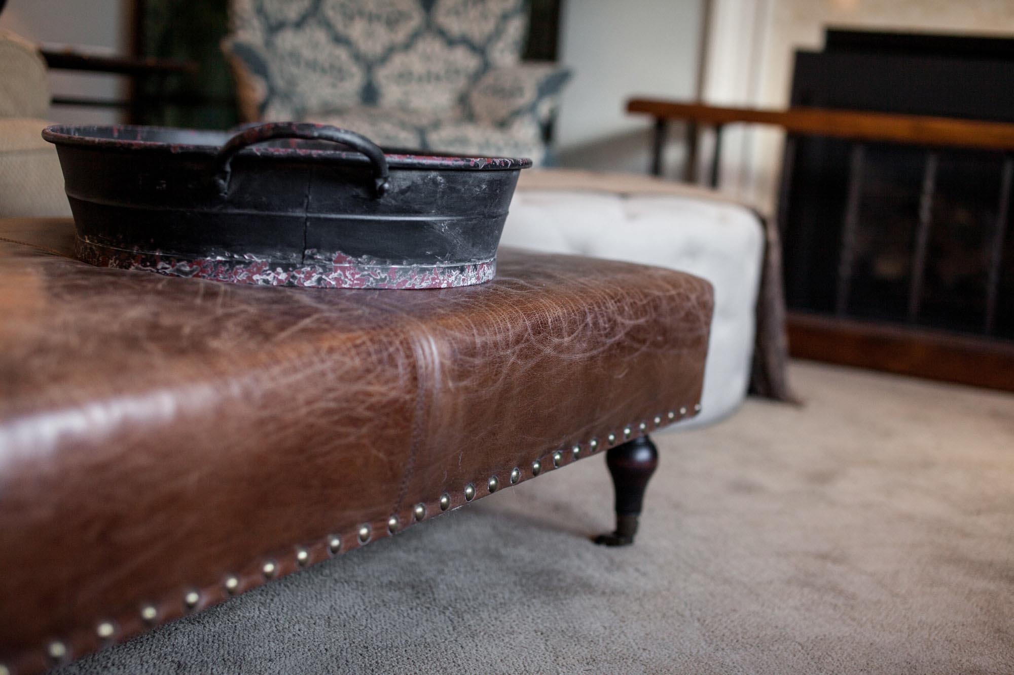 Brown leather ottoman with metal tray and comfortable seating