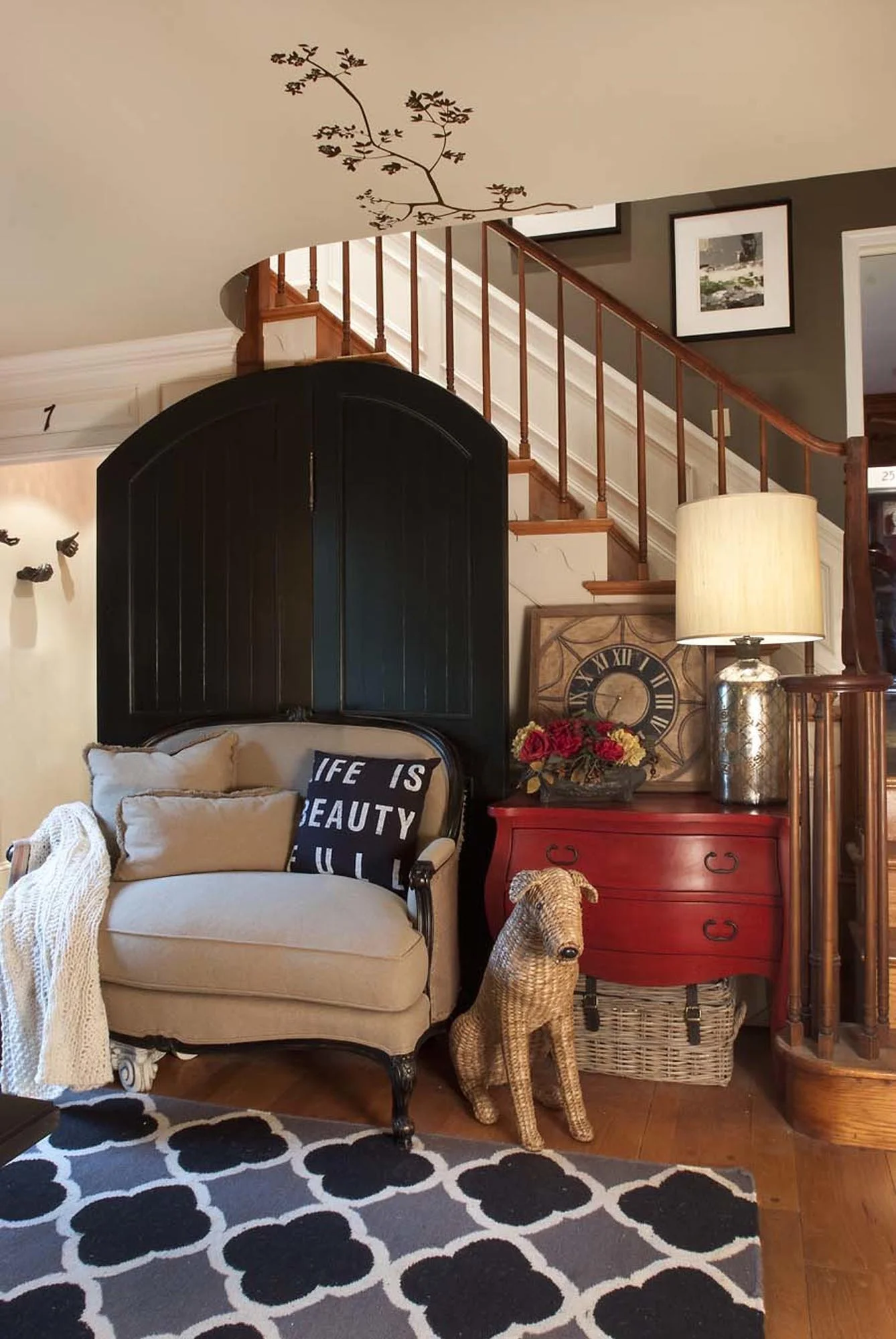 Comfortable seating area with soft loveseat and burlap style stuffed dog and red dresser
