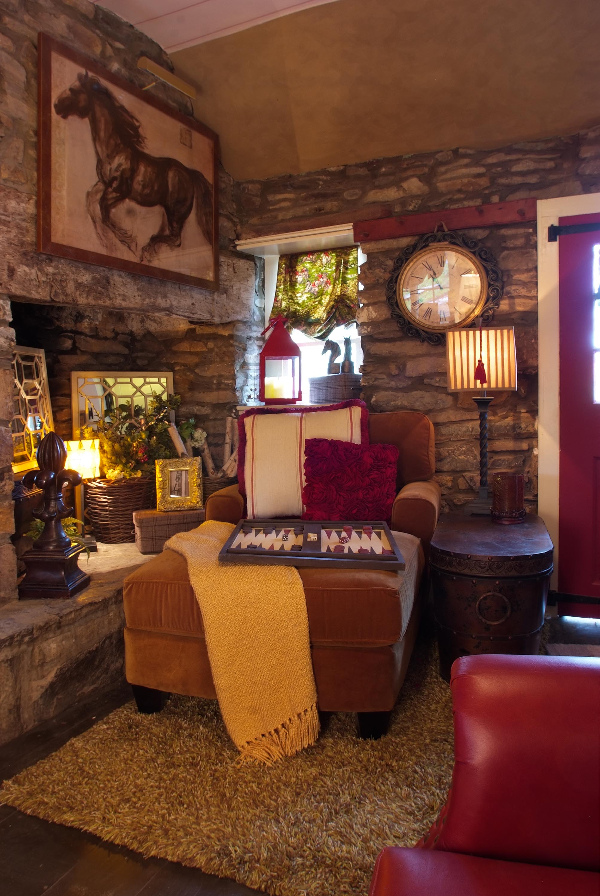 Plush seating with framed painting of horse mounted above mantle