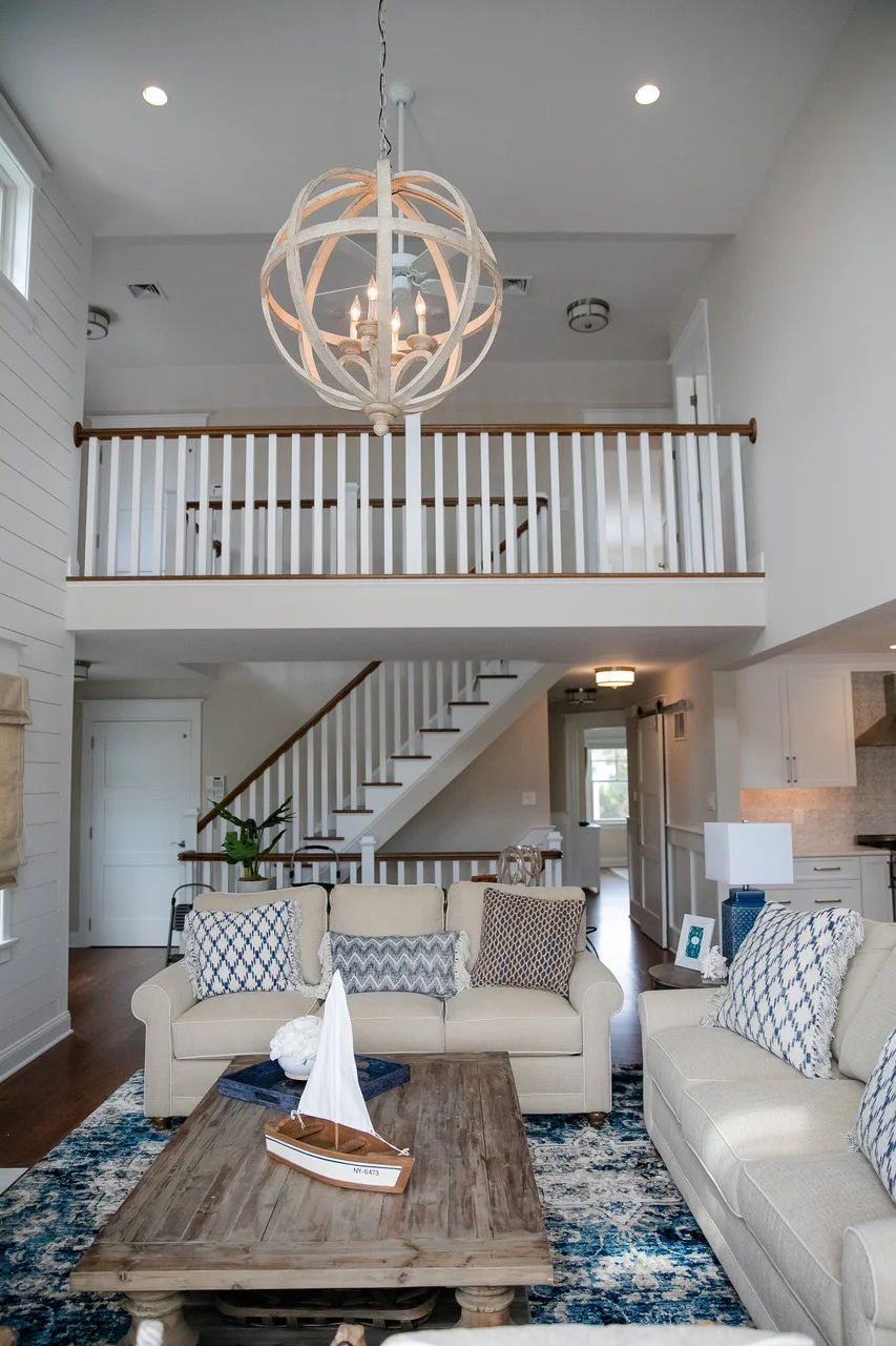 Vaulted ceiling living room space with sailboat accessory on wooden coffee table