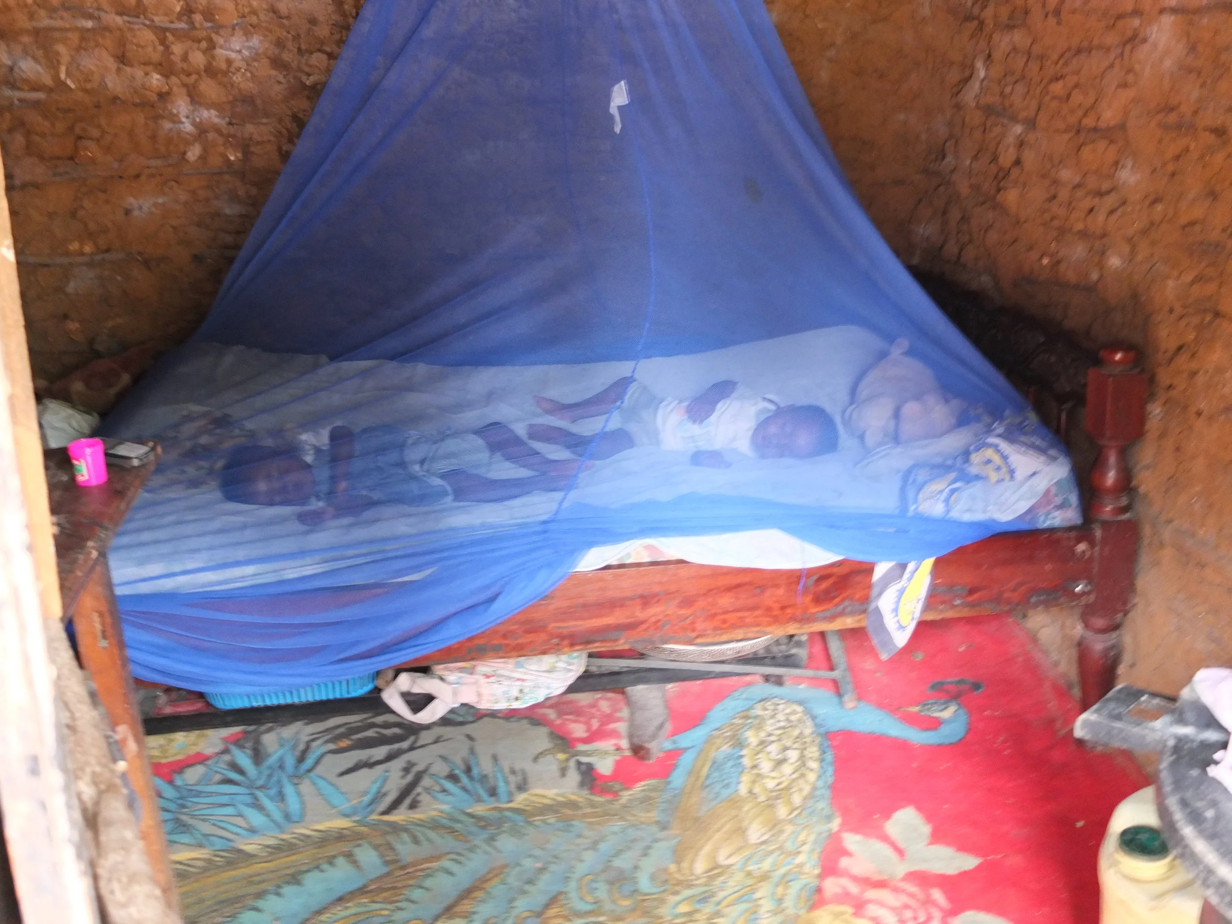 Mosquito Net in use (2013). One mother told her that none of her children had been sick with Malaria that rainy season, thanks to her mosquito net. Donate £7.50 to buy one for another family.