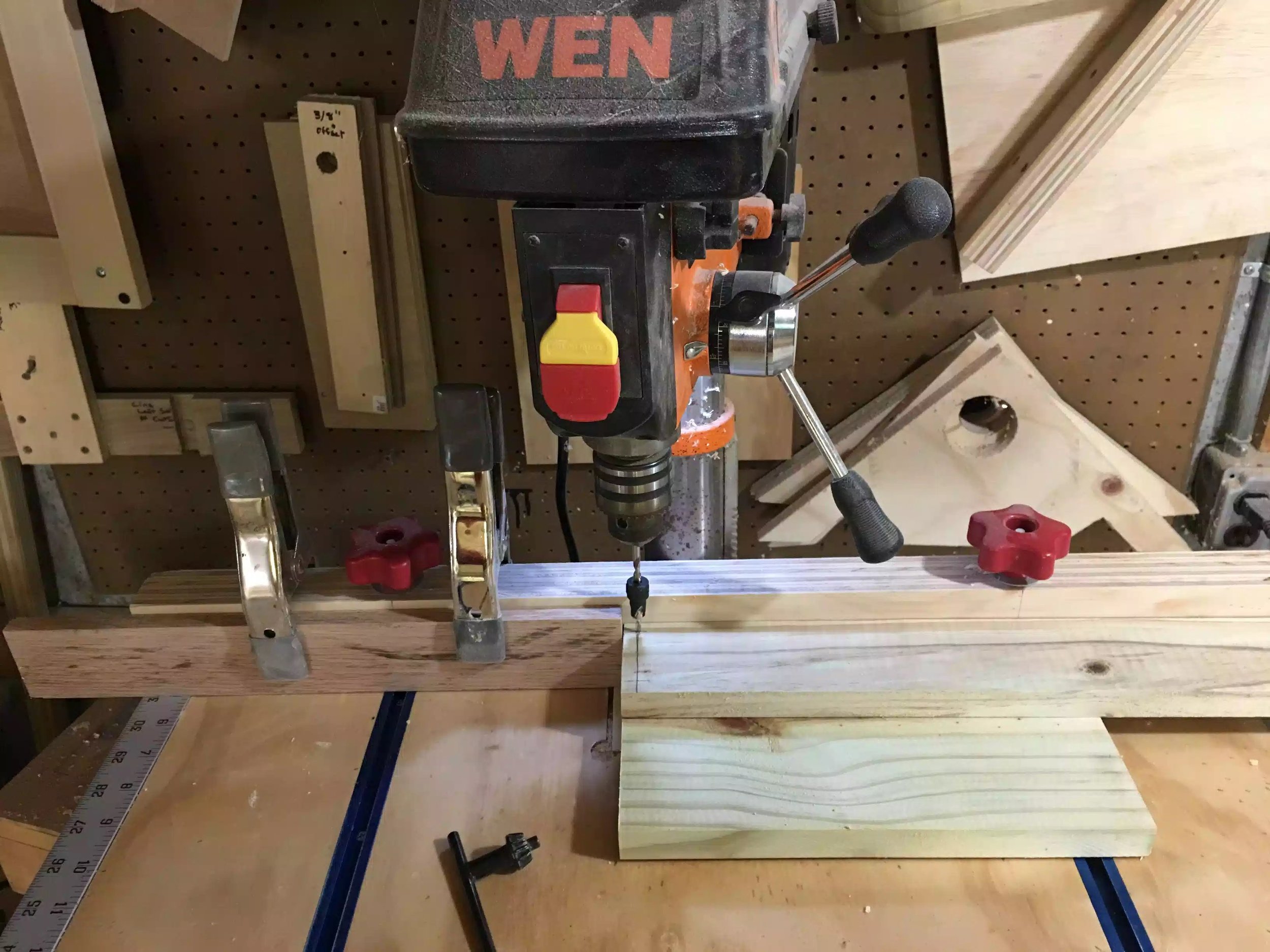 Here is the drill press and table with the stop block clamped to my fence. I marked the pieces 3/8" from each face as they were being drilled in 3/4' thick frames.