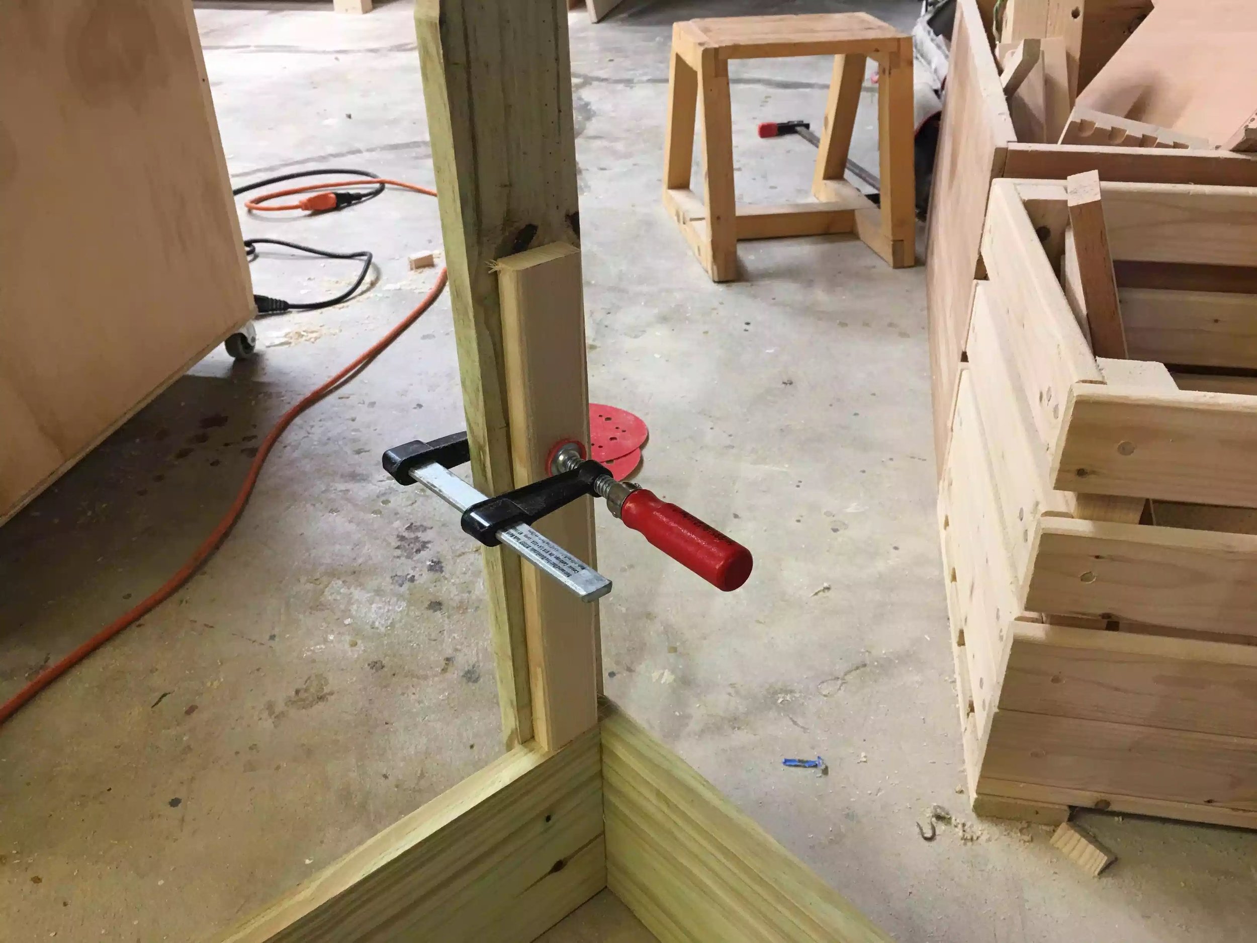 Here is the spacer clamped to the leg with a clamp, I added 1 of these assemblies to each leg, they are resting on the bottom edge of the top frame
