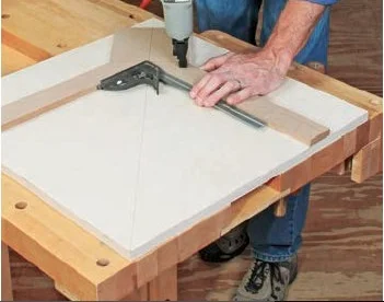 After mitering the corners of the fences to 45°, pin them in position and making sure everything lines up using a square. (stock photo)