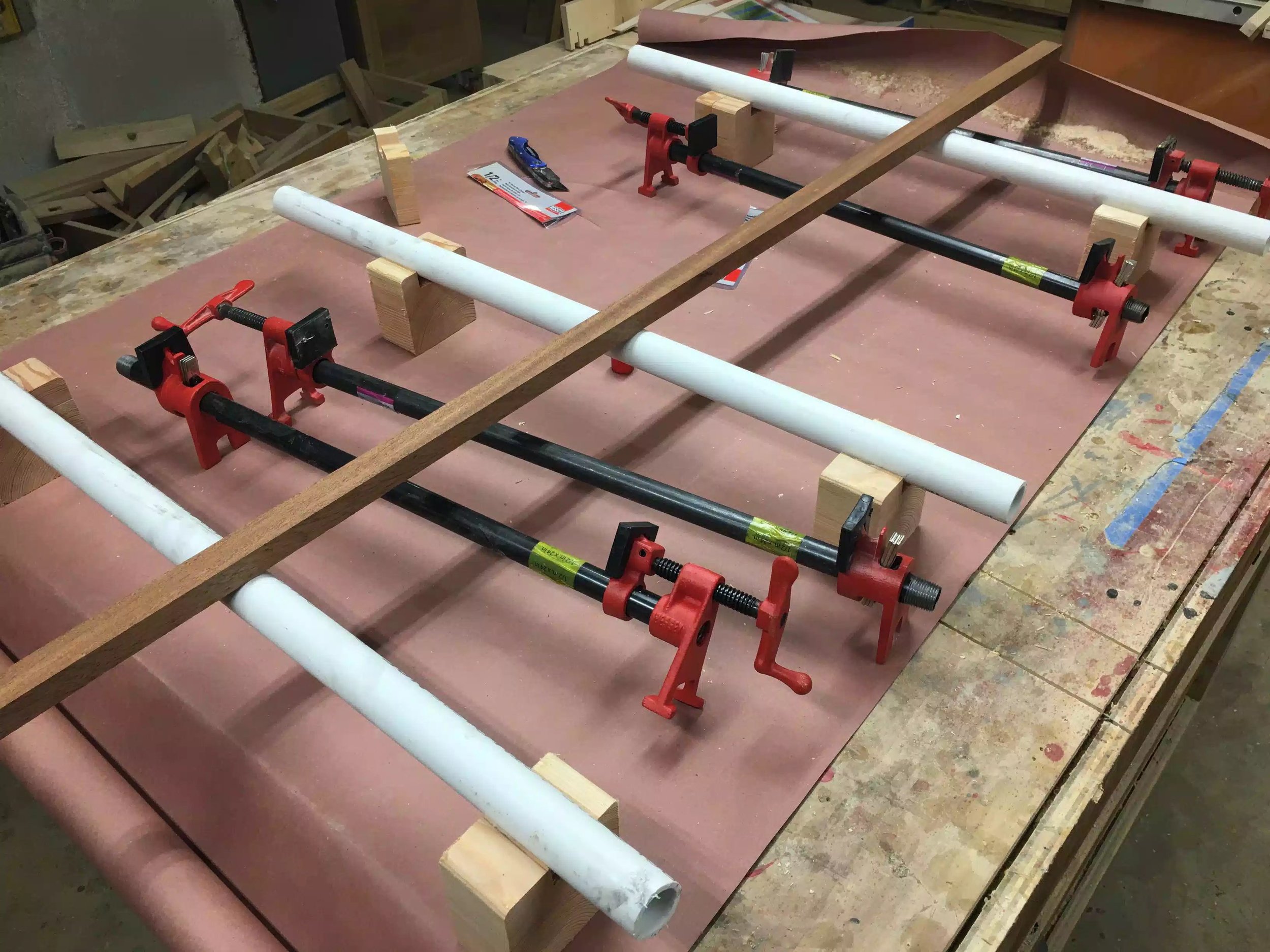 The idea of the white pipe was that it gave the work-piece a flat surface to sit on, and it also afforded me to add height to the glue up so as that I could place clamps on the bottom and top surfaces of the work-piece.