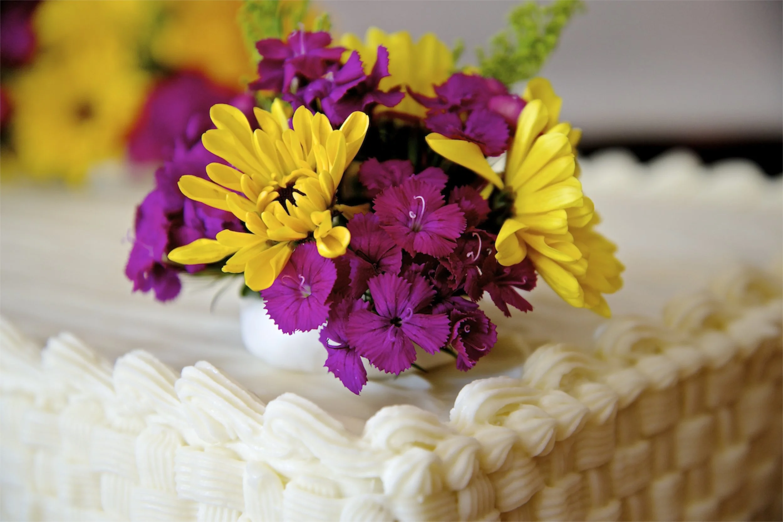 Fresh flowers atop a large sheet cake
