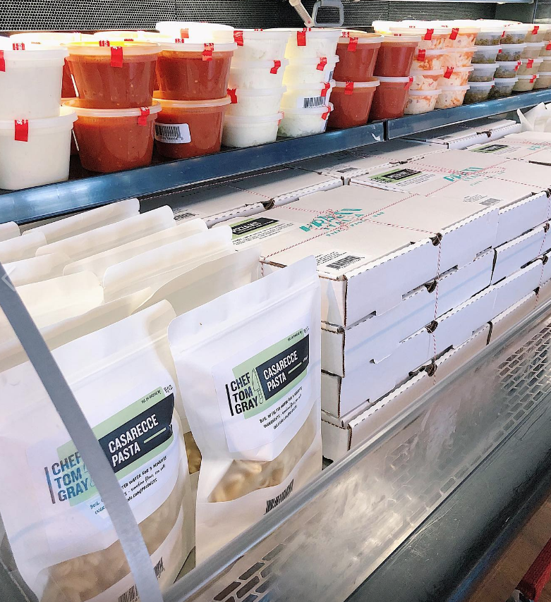 Grocery display case full of fresh made pastas and sauces from Chef Tom Gray