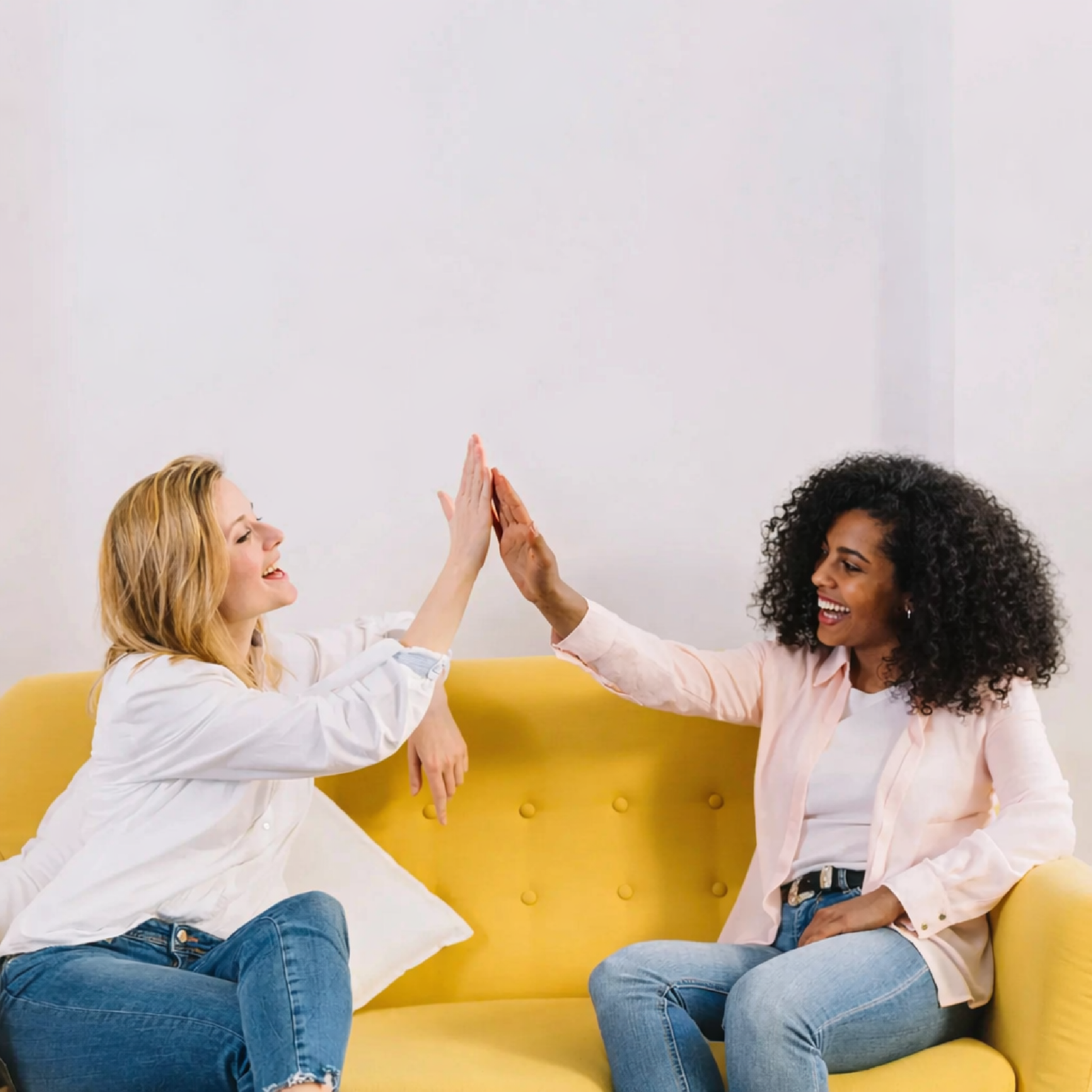 Joyful high-five on a yellow couch (2).png