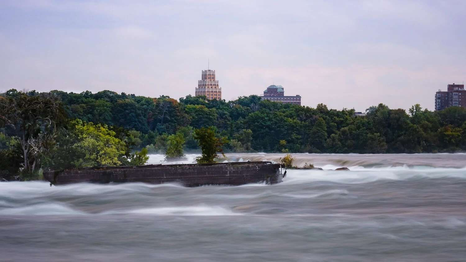 The abandoned scow shipwreck in the upper rapids, Niagara Falls. Travel photography and guide by © Natasha Lequepeys for "And Then I Met Yoko". #niagara #niagarafalls #ontario #canada #discoverontario #niagaraonthelake #travelguide #photoblog #travelblog #travelphotography #landscapephotography #travelitinerary #fujifilm #shipwreck #ontariohistory #longexposure #notl #travelblogger #niagaraitinerary #niagaraphotography