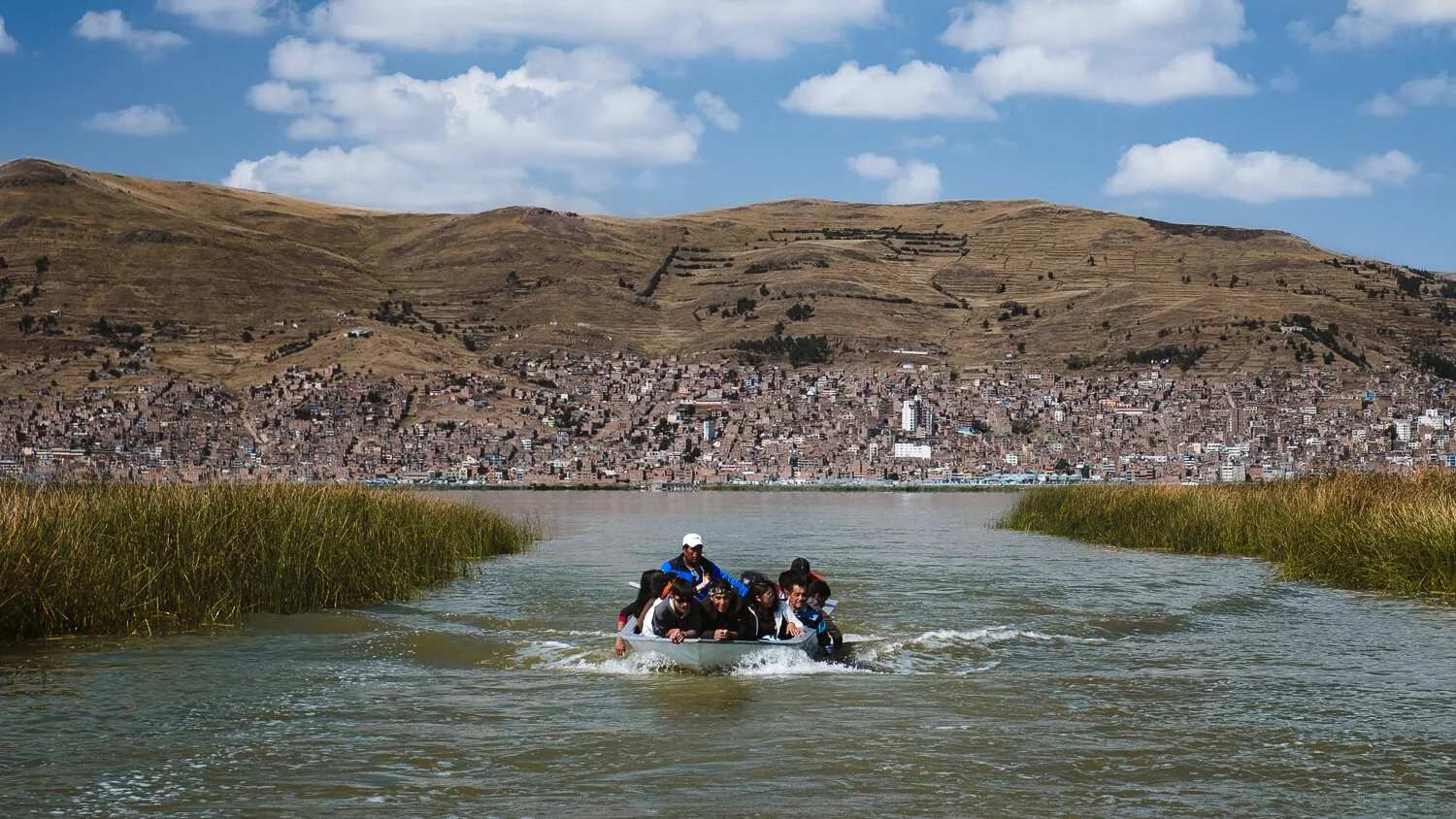 Locals on their boat, leaving Puno. Travel photography and guide by © Natasha Lequepeys for "And Then I Met Yoko". #peru #laketiticaca #amantani #taquile #homestay #culturalexperience #photoblog #travelblog #travelphotography #fujifilm #travel #travelperu #southamerica #allwaystravel #laketiticacaitinerary #puno #uros #floatingislands #pachamama #pachatata