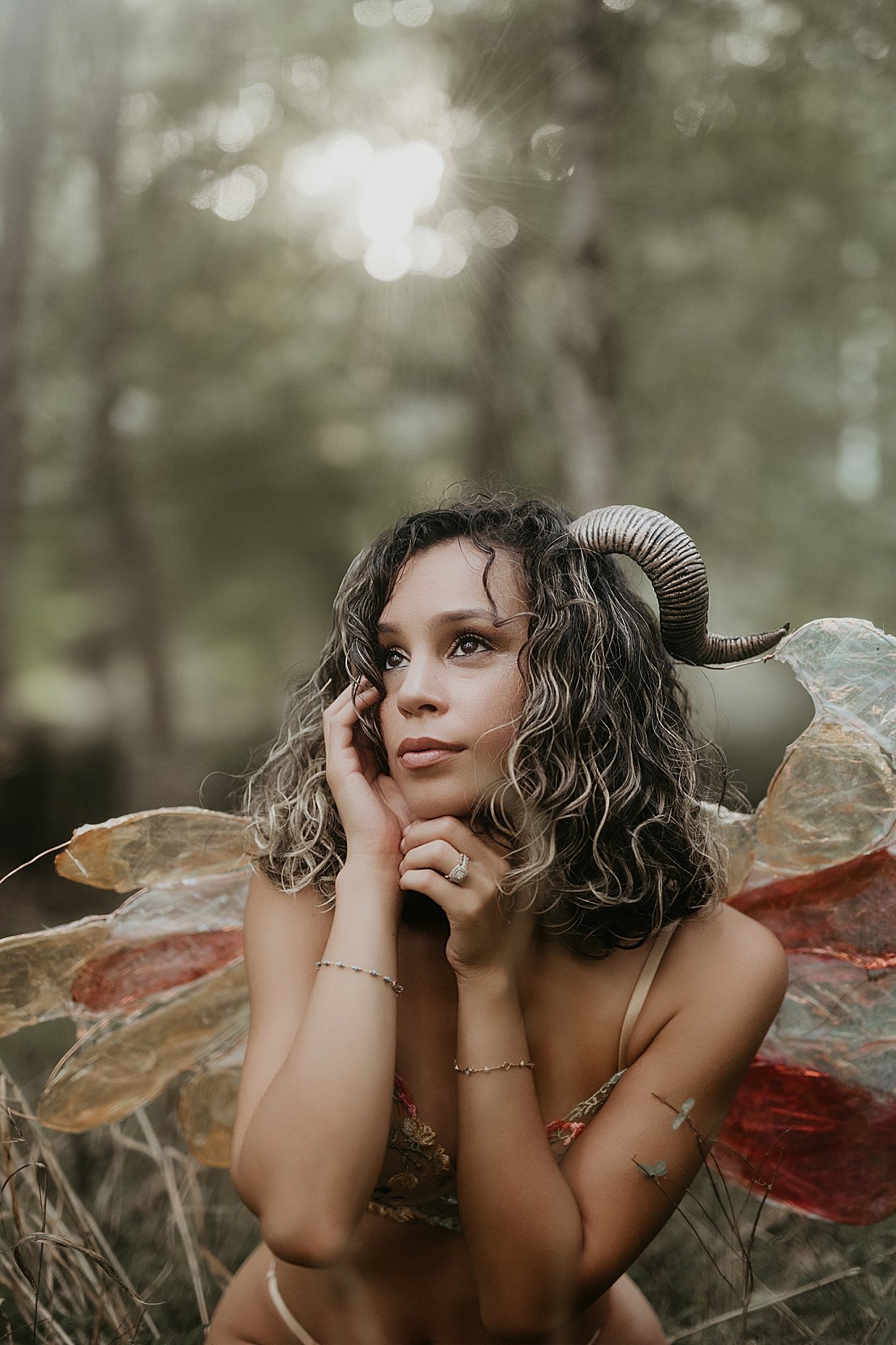 Fine art fantasy photography portrait of a woman in a forest wearing horned headpiece.