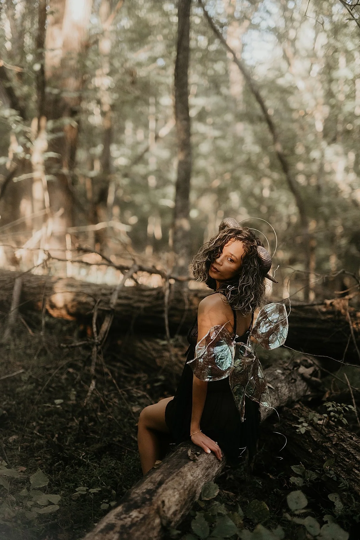 Conceptual fantasy portrait photography of a woman with handmade wings in a forest.