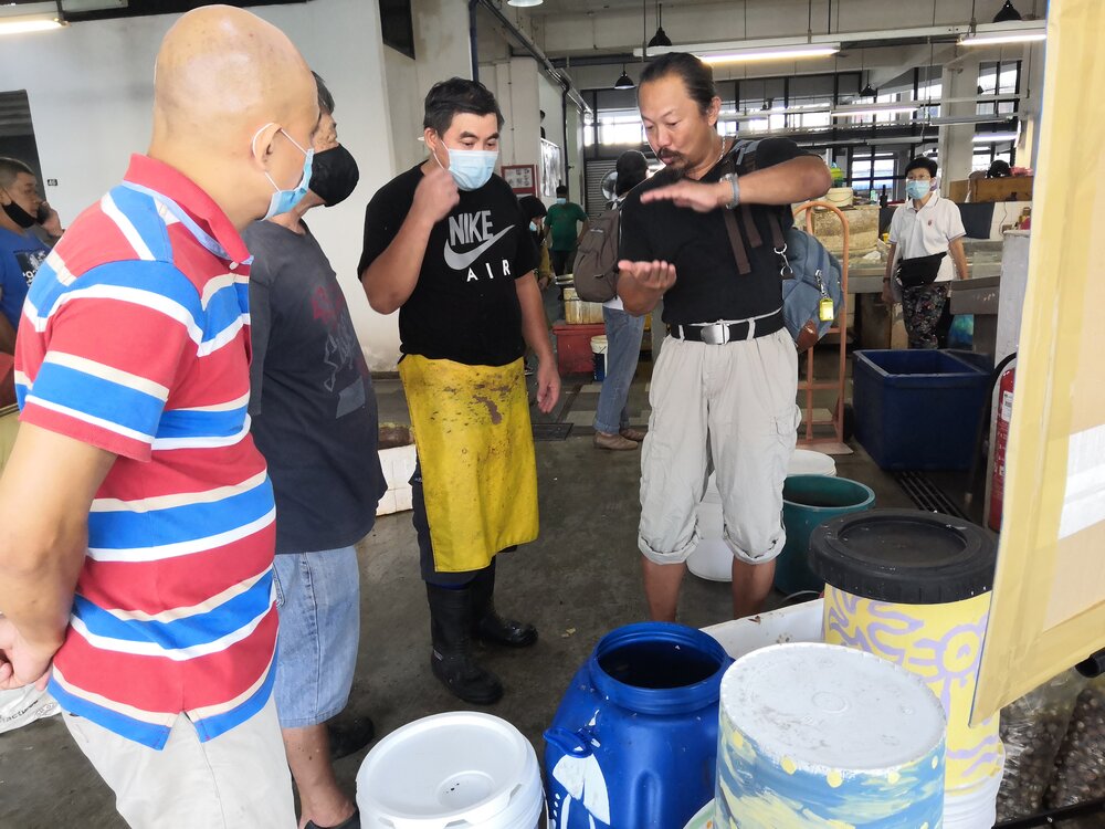  Knowledge sharing and learning session at the seafood section with Joseph (right), about the processes and benefits of using organic waste as a fertiliser. 