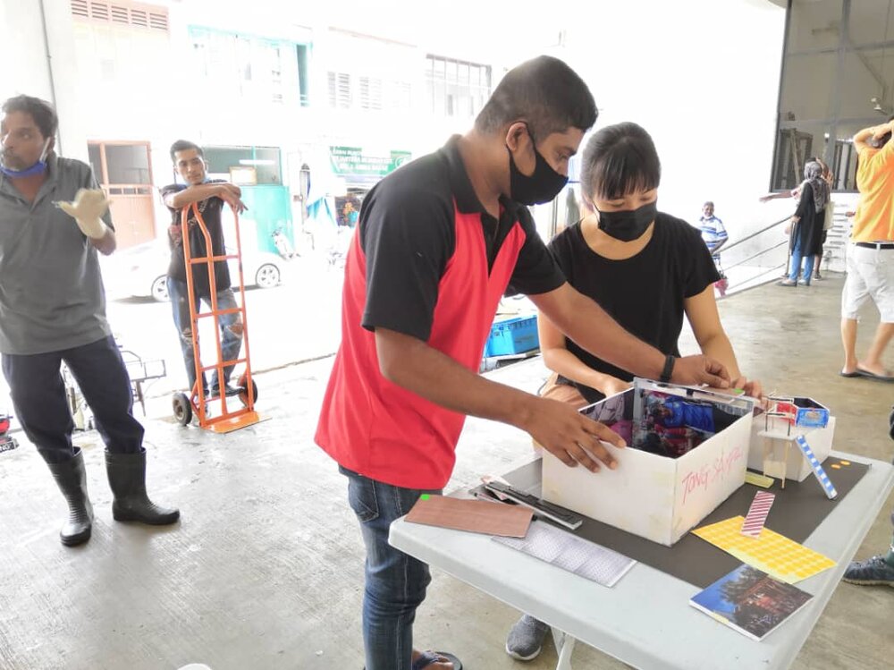  Mizan (second from right), Market Cleaner, giving feedback based on the 3D model of a RORO bin design. 