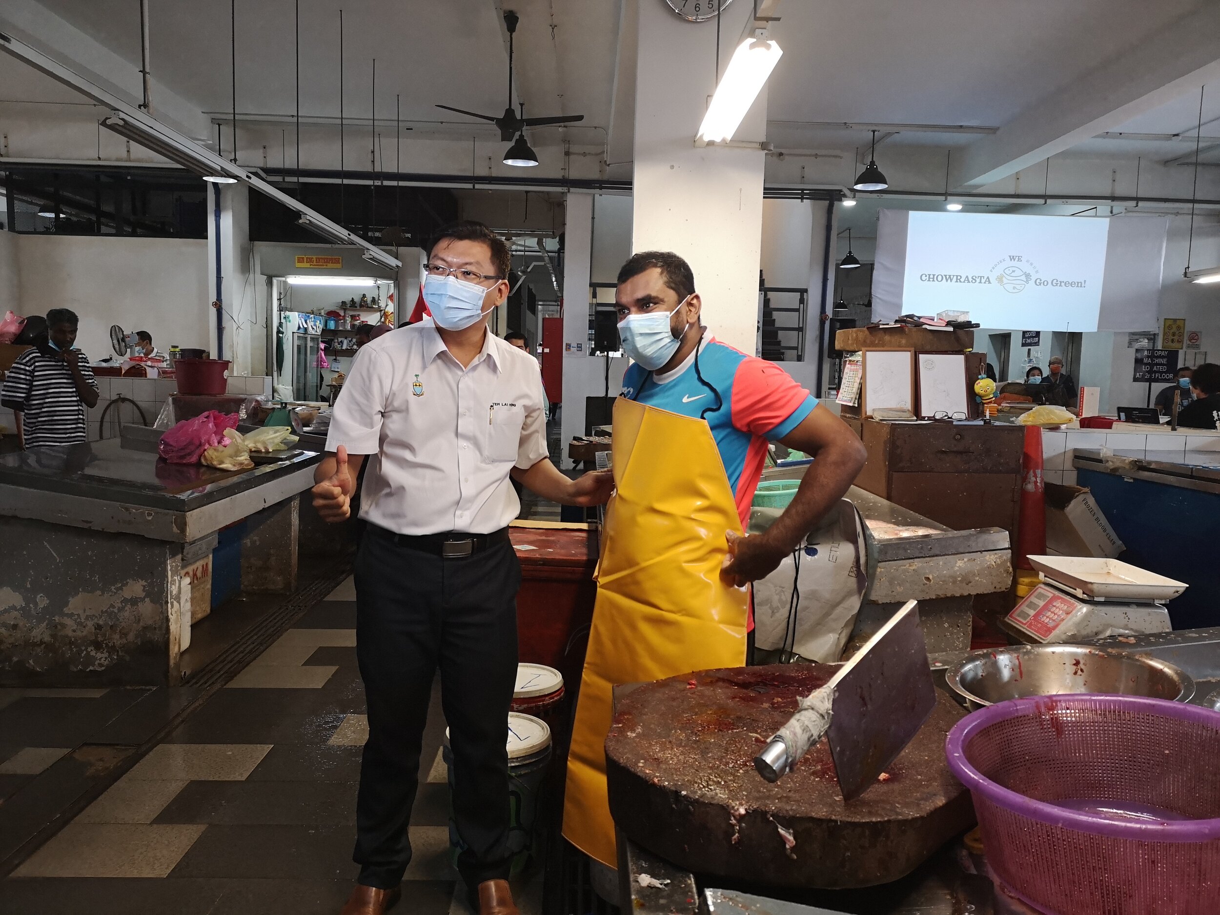 YB Teh Lai Heng, KOMTAR assemblyman (left) presenting an apron to one of the vendors, Yasin, as a sign of appreciation for participating in the organic waste upcycling process. 