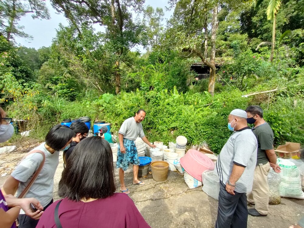  The farmer, Joseph (in the middle) explains the process and importance of waste separation. 