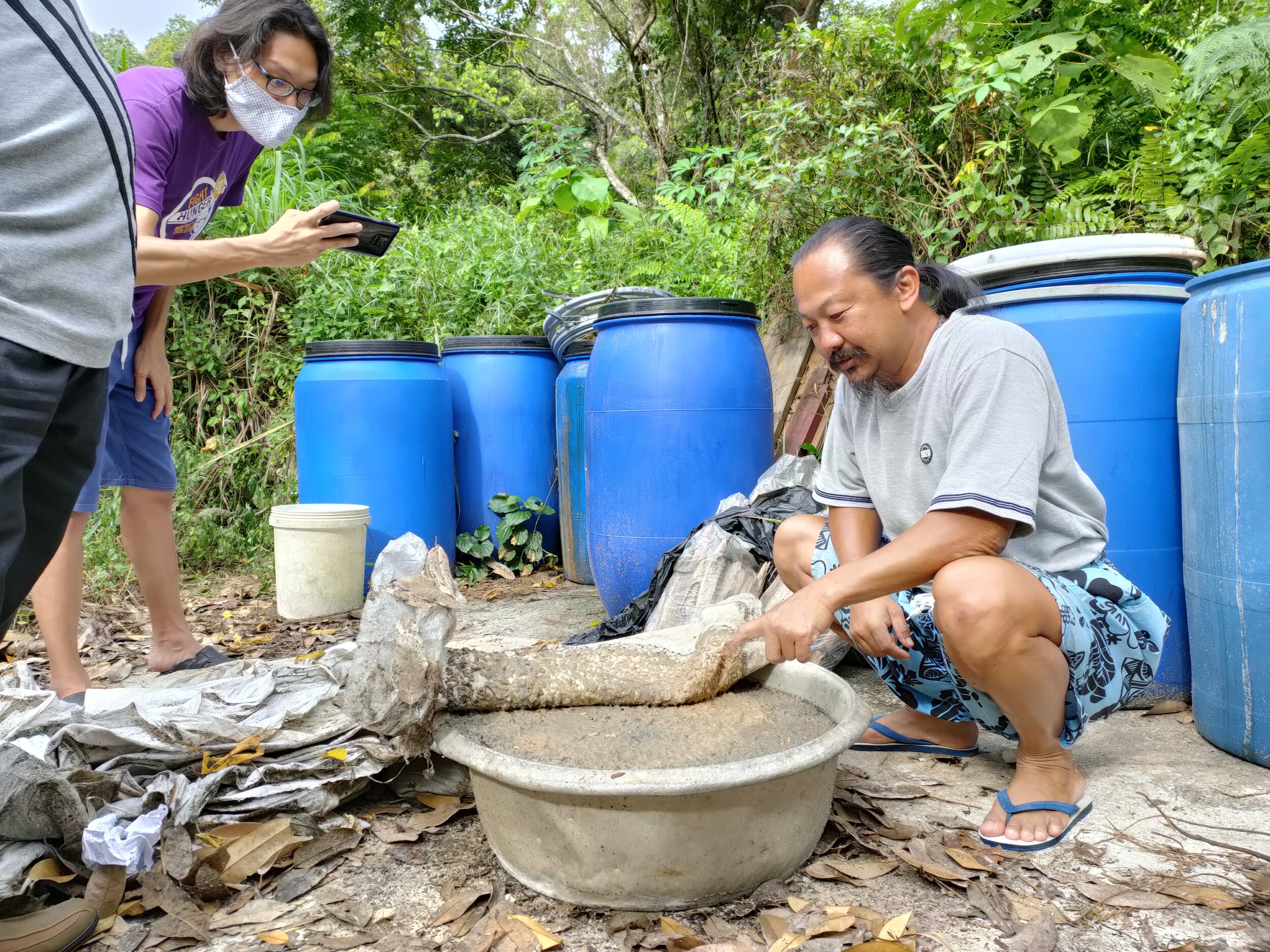  Joseph (right) showing coconut waste turned into fertilizer using black soldier fly larvae. 