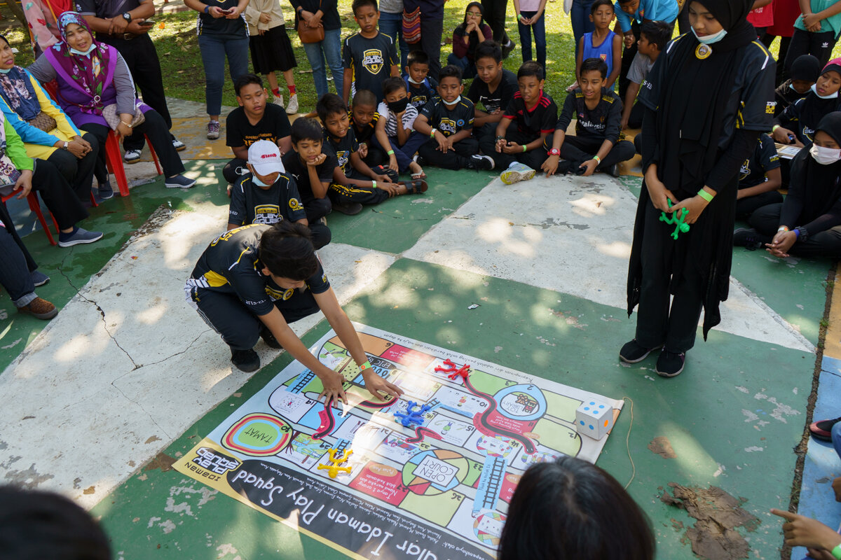  The young participants showing the adults how to play the game they adapted from the Snake and Ladder. 