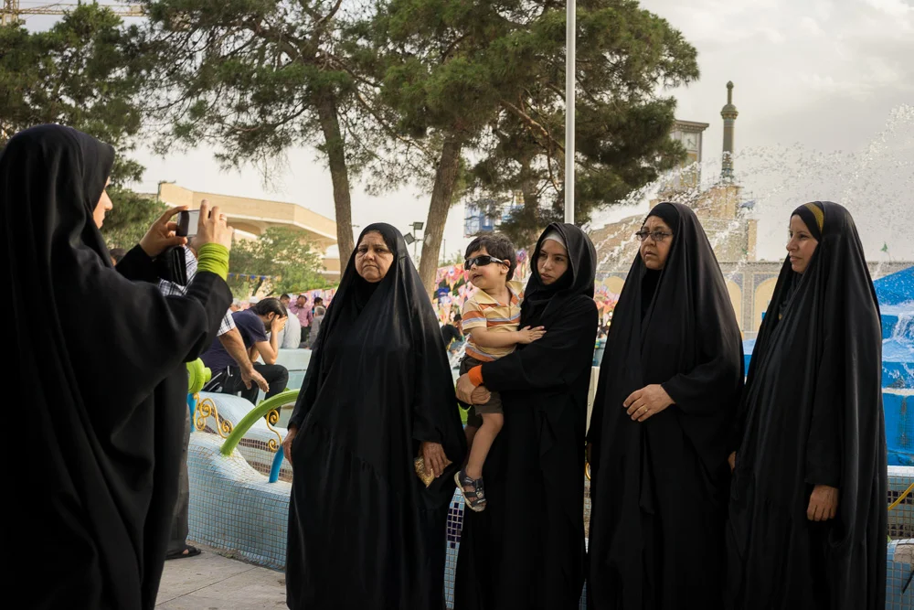 June 11, 2014 - Qom, Iran. A family of pilgrims take a souvenir picture outside the shrine of Hazrat-e Masumeh in Qom. The shrine is considered one of the most significant Shi'i shrines in Iran and every year, thousands of Shi'i Muslims travel to Qom to honor Fatima Masumeh and ask her for blessings. © Thomas Cristofoletti / Ruom