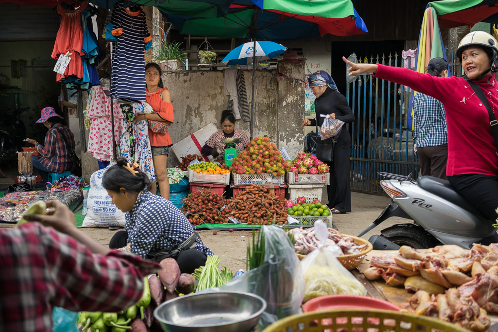  August 05, 2014 - Phnom Penh. Champa buys fruits in a market stall in front of her house. Champa is the first openly transgender boxer in Cambodia. Because of the discrimination she endures as a transgender boxer, she was forced to quit her professi