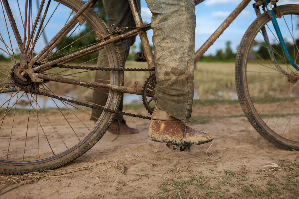  November 28, 2013 - Sterng Chey Commune (Kompong Cham). Mr En Noy (55) rides his bycicle on the way back to his home. He was a soldier during the war and he lost a leg as the conseguence of a bullet. Nowadays he has a small bike repair shop in the v