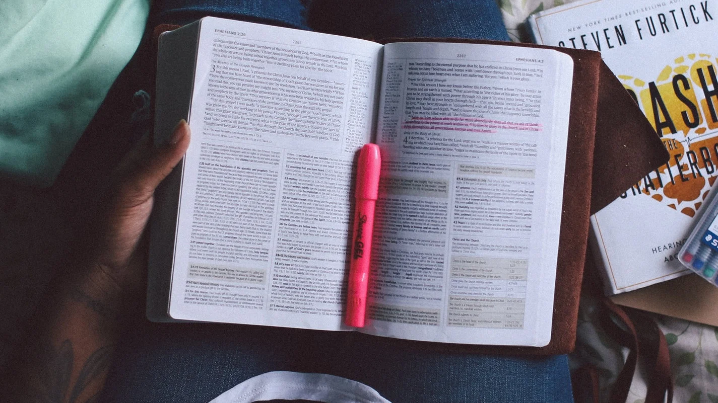 a book with a highlighter sitting in the middle of it.