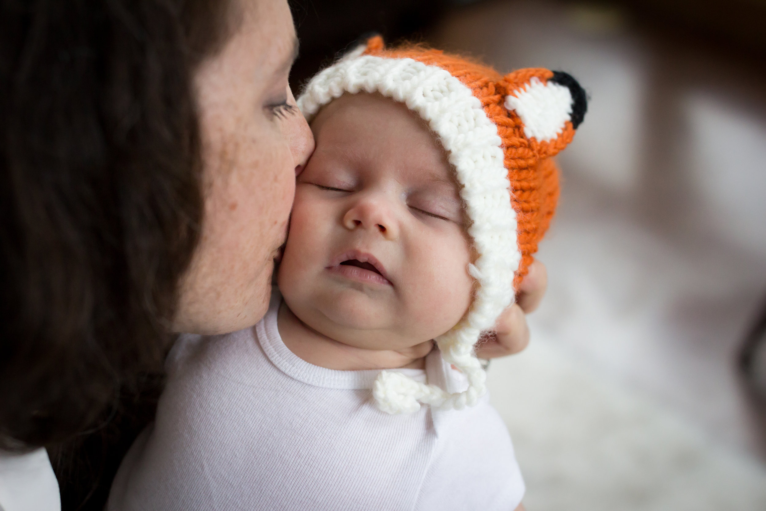 Mom kissing newborn in fox hat | Jaime Bugbee Photography