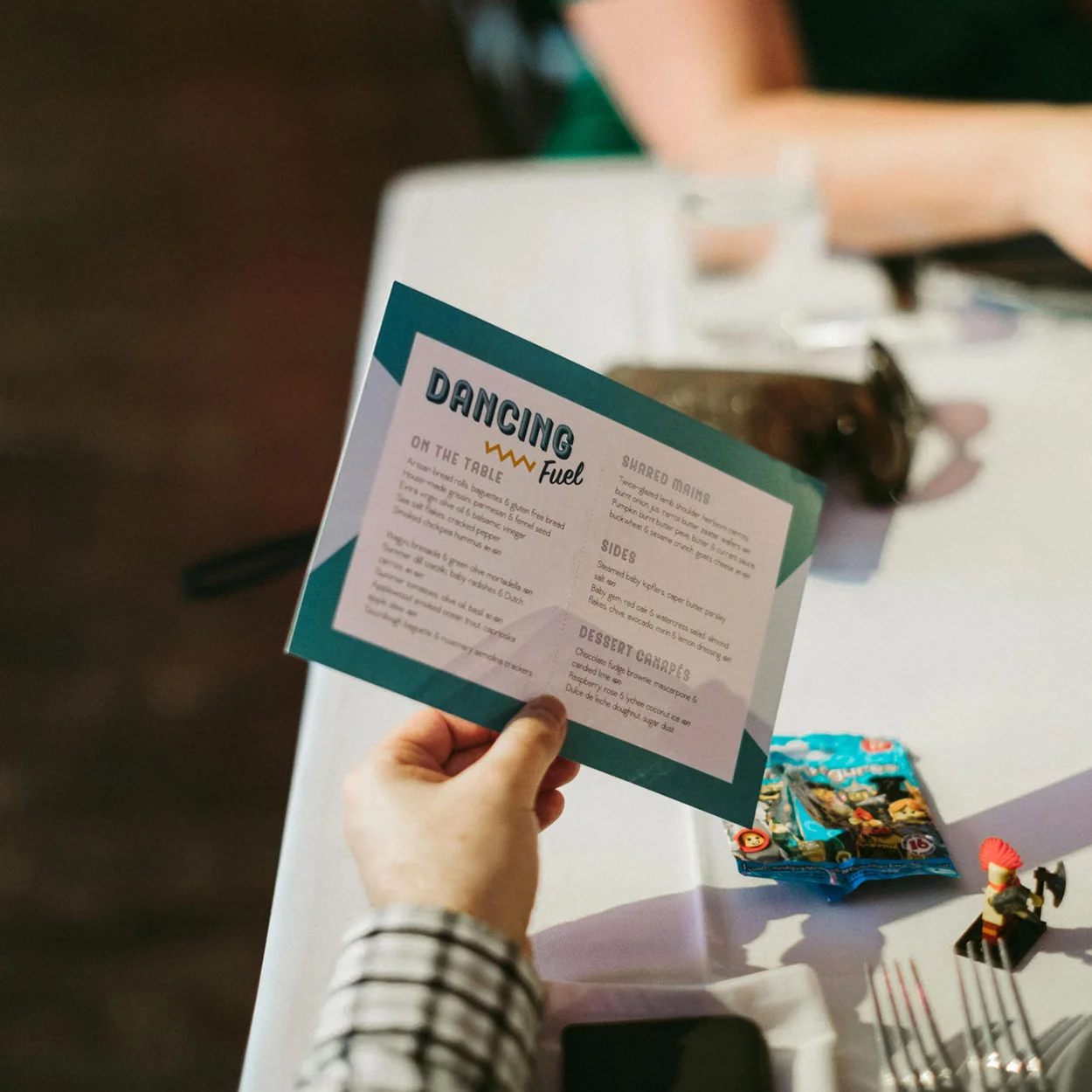 Wedding menu held by male hand close up with custom typography