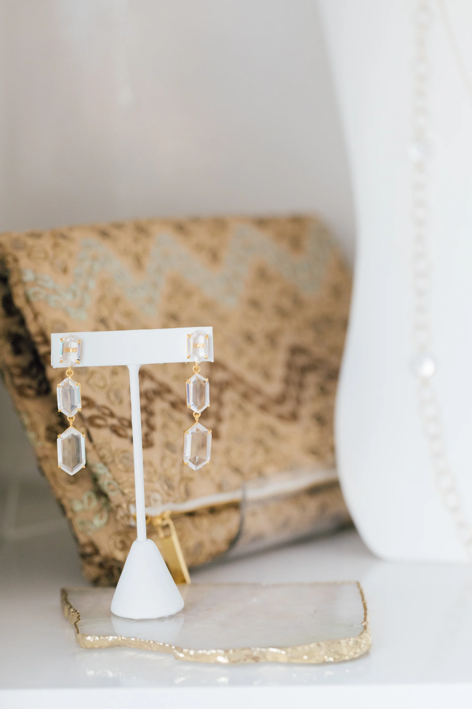 Andrea Del Bello Triple Hexagon Drop Earrings in Clear Quartz paired with an Omluxe bag perfect for that next special occasion.