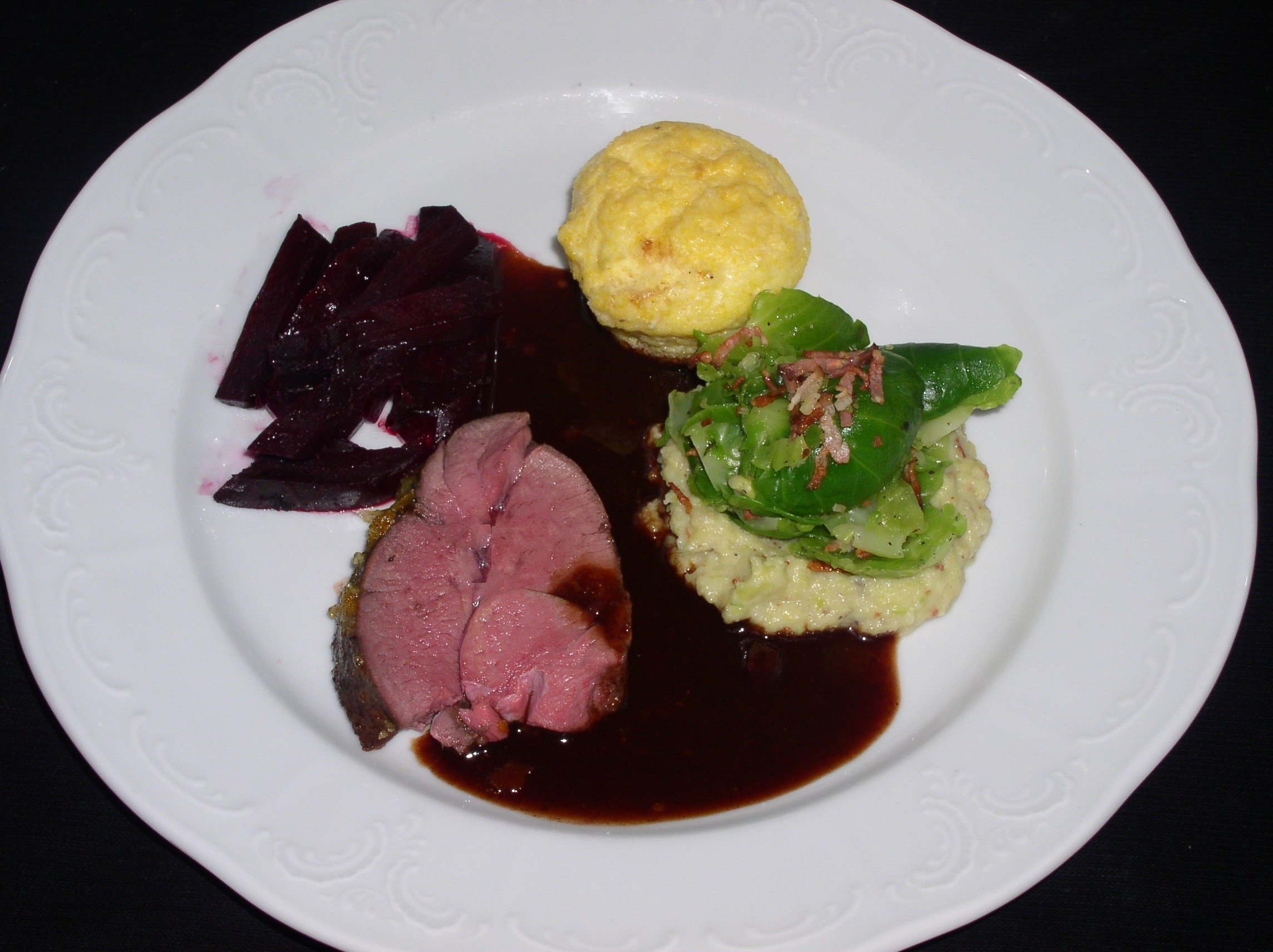 Glacierte Rehkeule mit Orangenkruste, Rote Rüben, Kohlsprossenpüree und Polentapudding