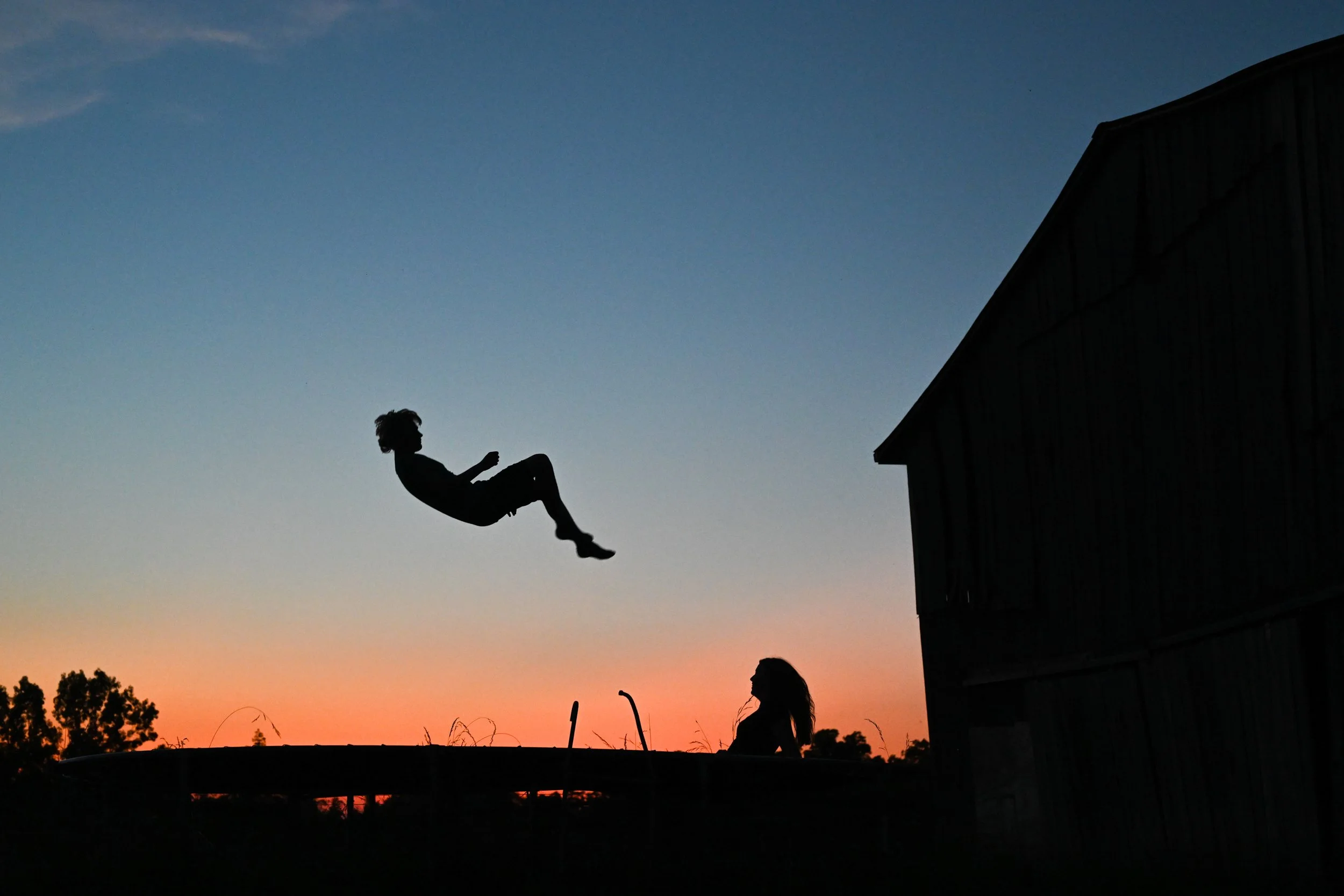 Henry Haag and his girlfriend Brooklyn bounce on a trampoline as the sun sets on Wendell Haag’s farm in Olivet, Kentucky, on Sunday, June 16, 2024.