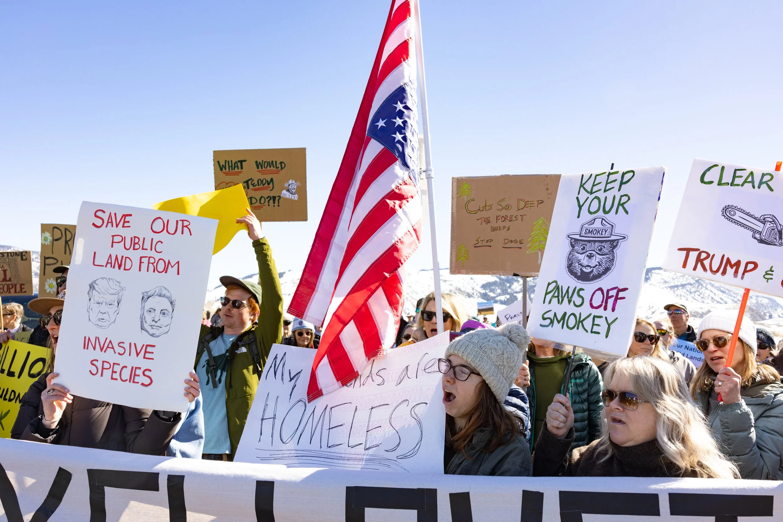 As part of a nationwide protest, about 200 people gathered to support public lands and oppose the recent layoffs of federal employees by the Department of Government Efficiency (DOGE) at Yellowstone National Park in Gardiner, Montana, on Saturday, Ma