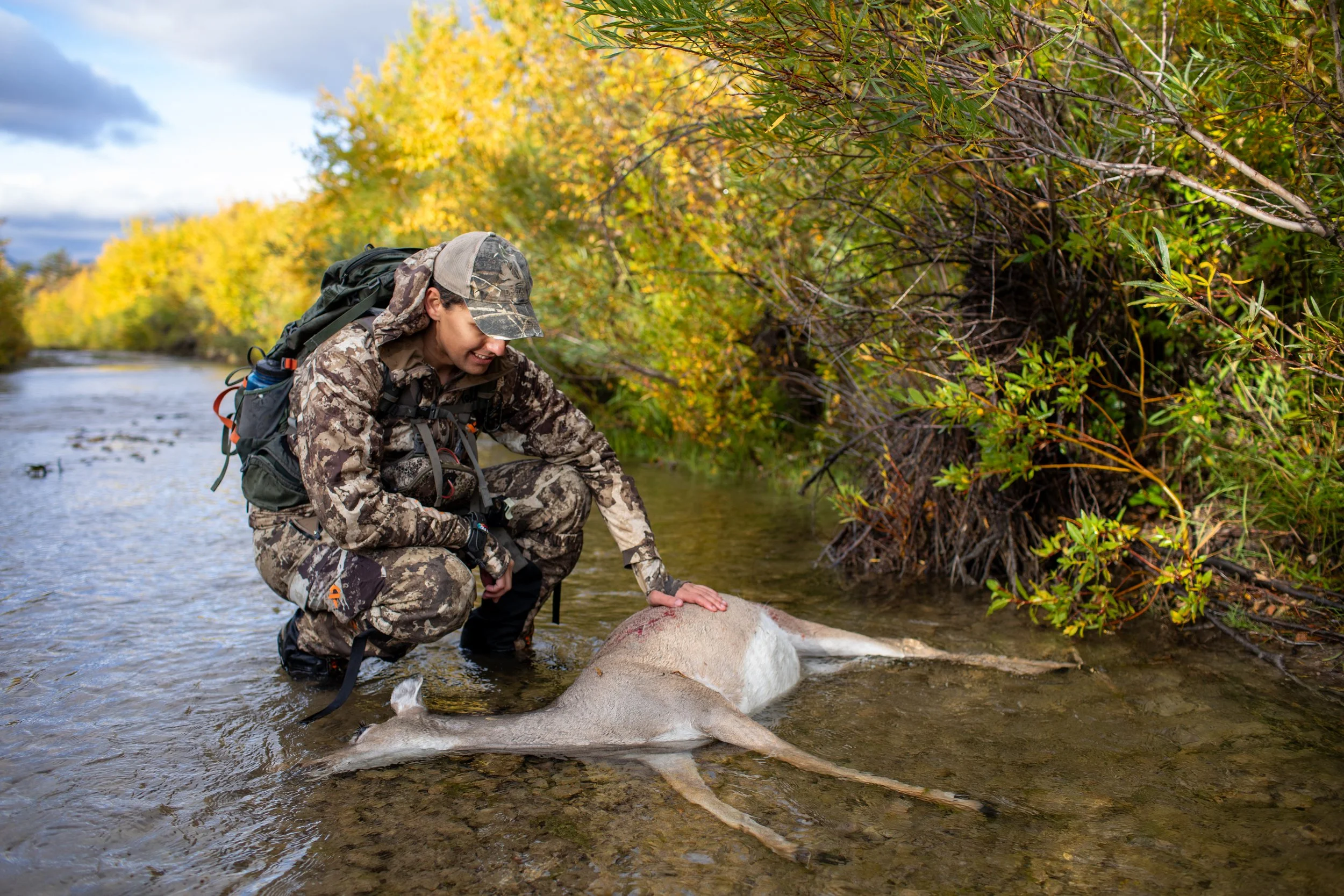 Marco Salvo retrieves a recently shot whitetail doe from a creek while bowhunting near Dupuyer, Montana on Saturday, September 23, 2023. Hunting is a time honored tradition in Montana, where one third of the state is made up of public land, for both 