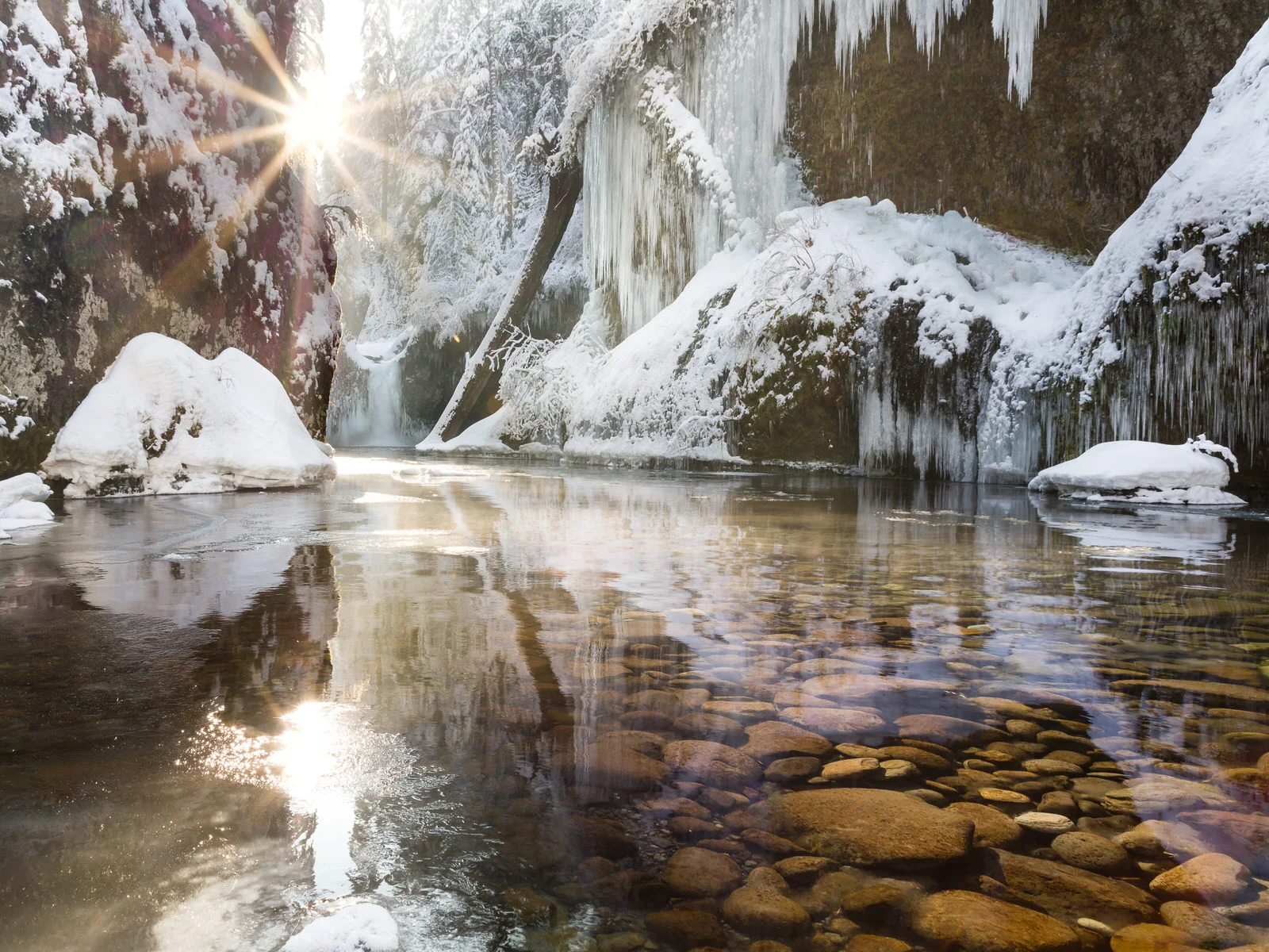 Sunburst behind frozen Punchbowl Falls