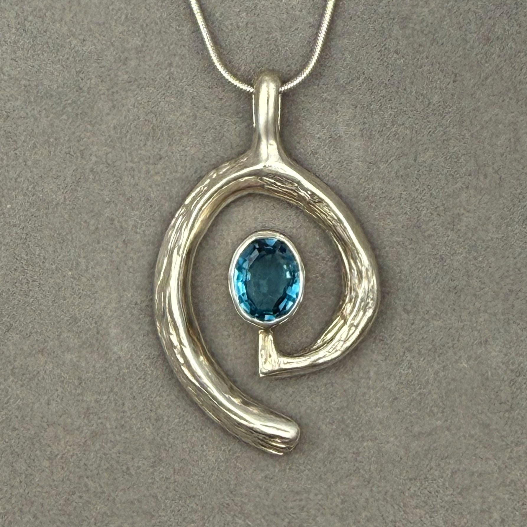 Blue-Topaz-Swirl-Pendant-on-grey.jpg