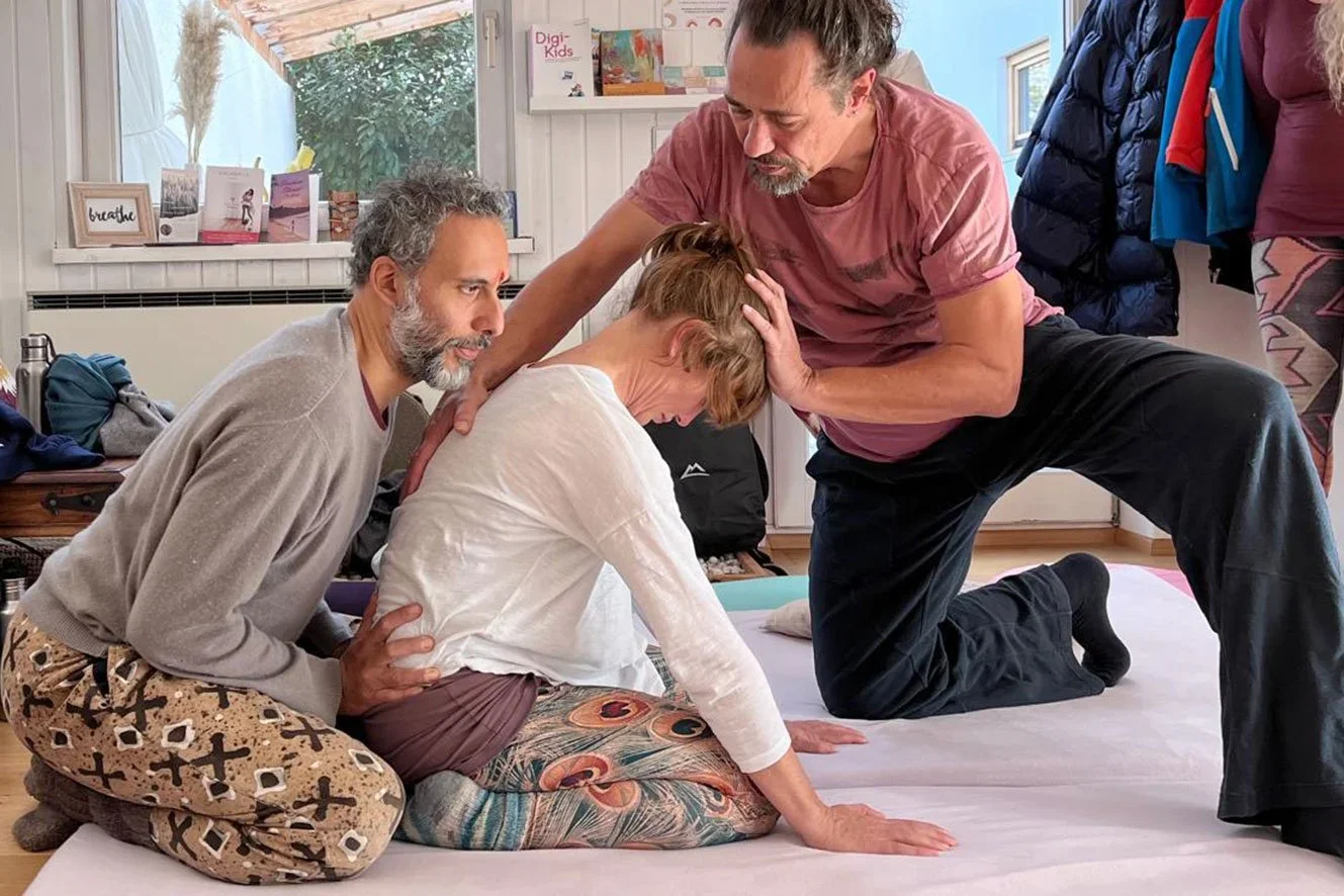 Une personne reçoit un massage ou une thérapie de la main d'un professionnel. L'image montre la main de ce professionnel manipulant la jambe ou le pied d'un autre individu.