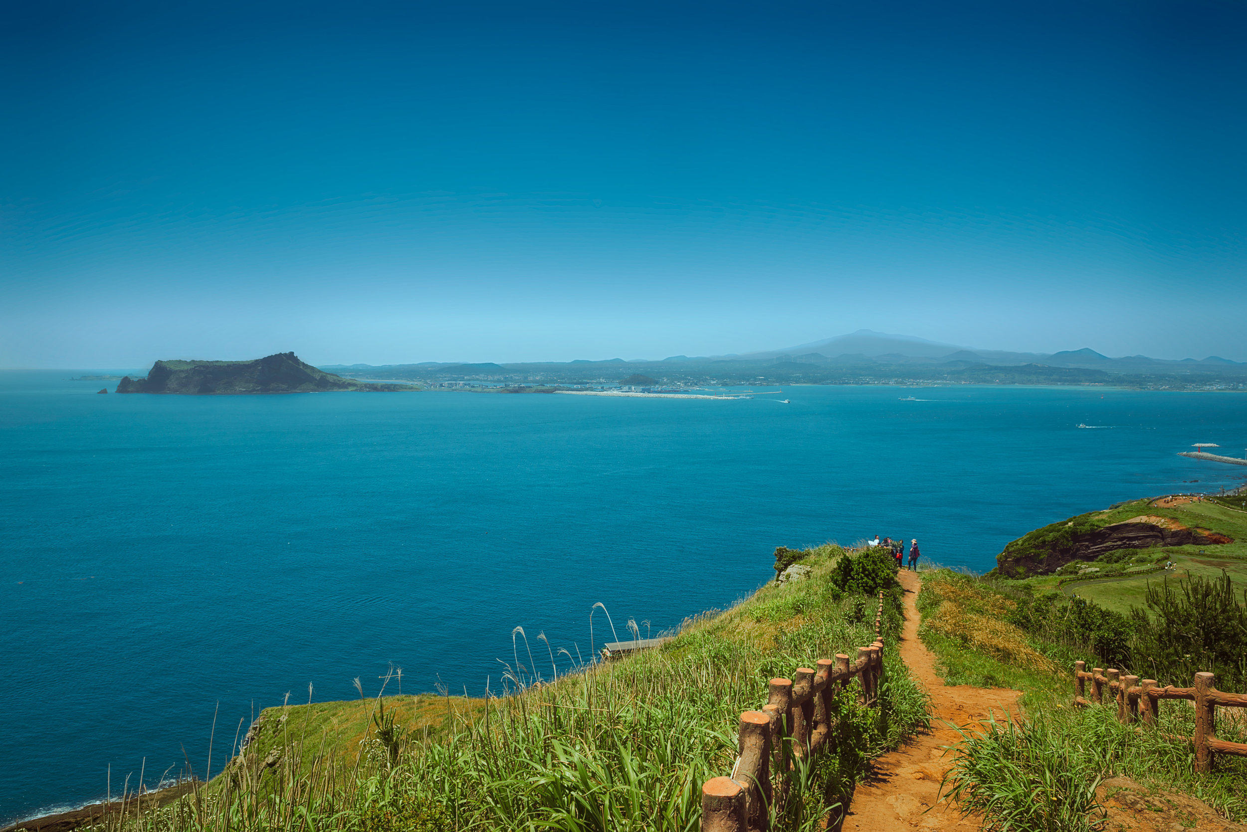 View from Udobong shows Jeju’s 2 biggest landmarks. On the left is Seongsan Ilchulbong (성산일출봉) and fading into the haze is Hallasan Mountain.