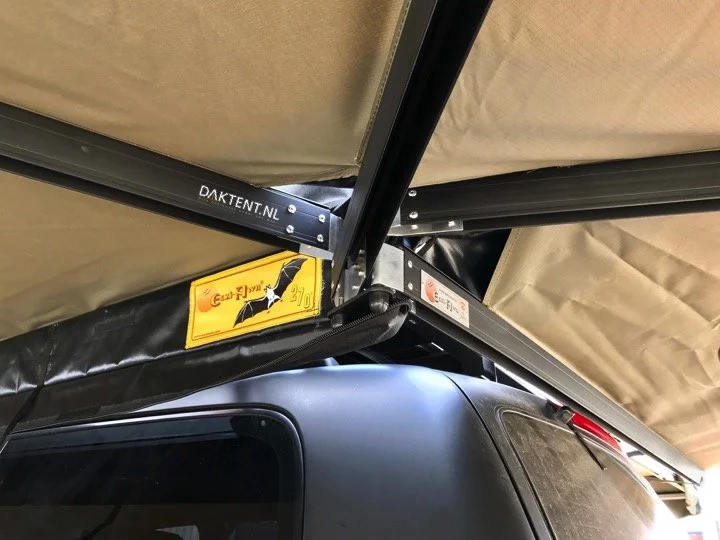 De binnenkant van een auto met een beschermkap boven de cabine, met een websiteadres en waarschuwingsreclame.