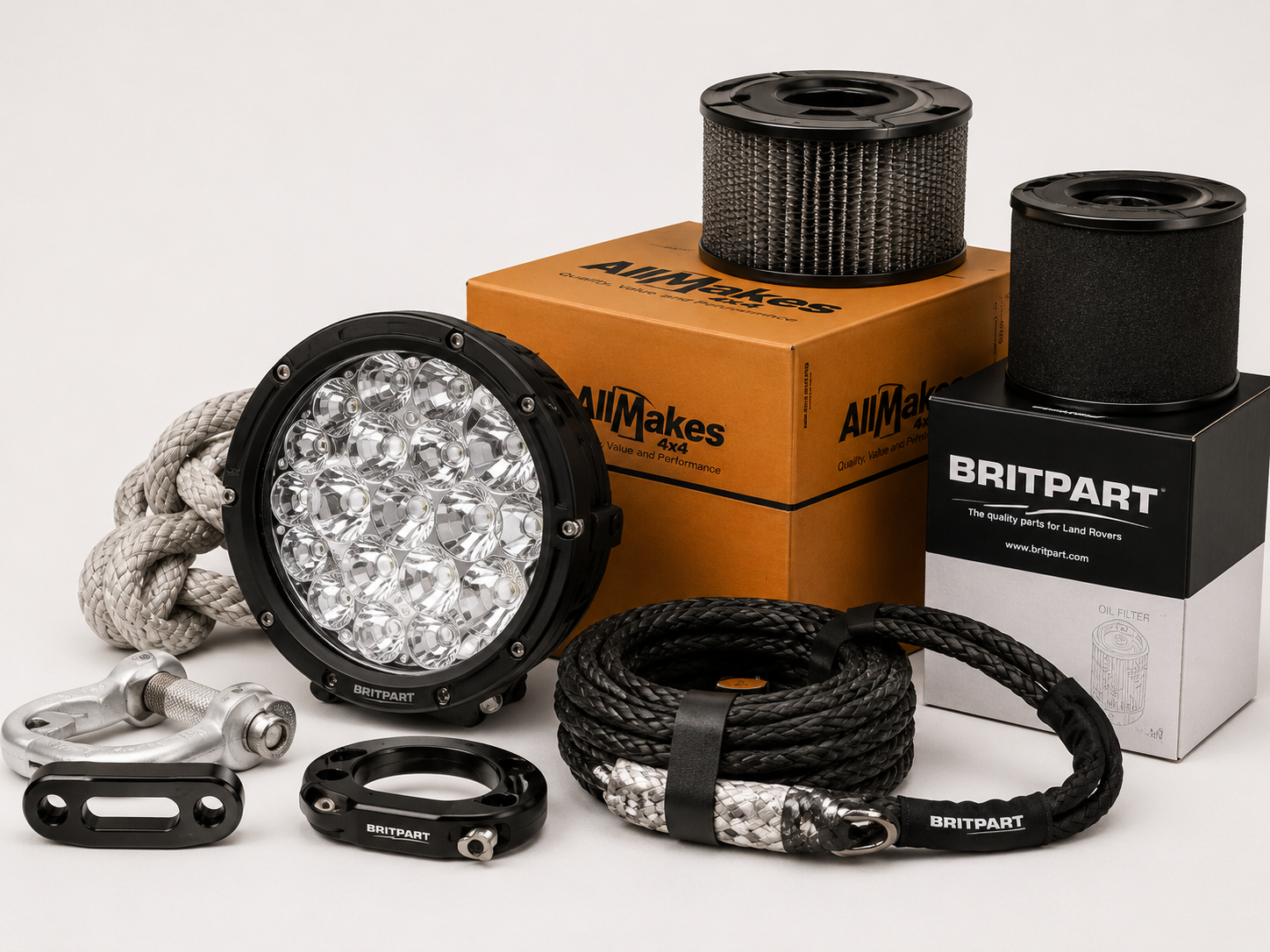Auto-onderdelen inclusief lamp, touwen en filters in pakketdozen en op een witte achtergrond.
