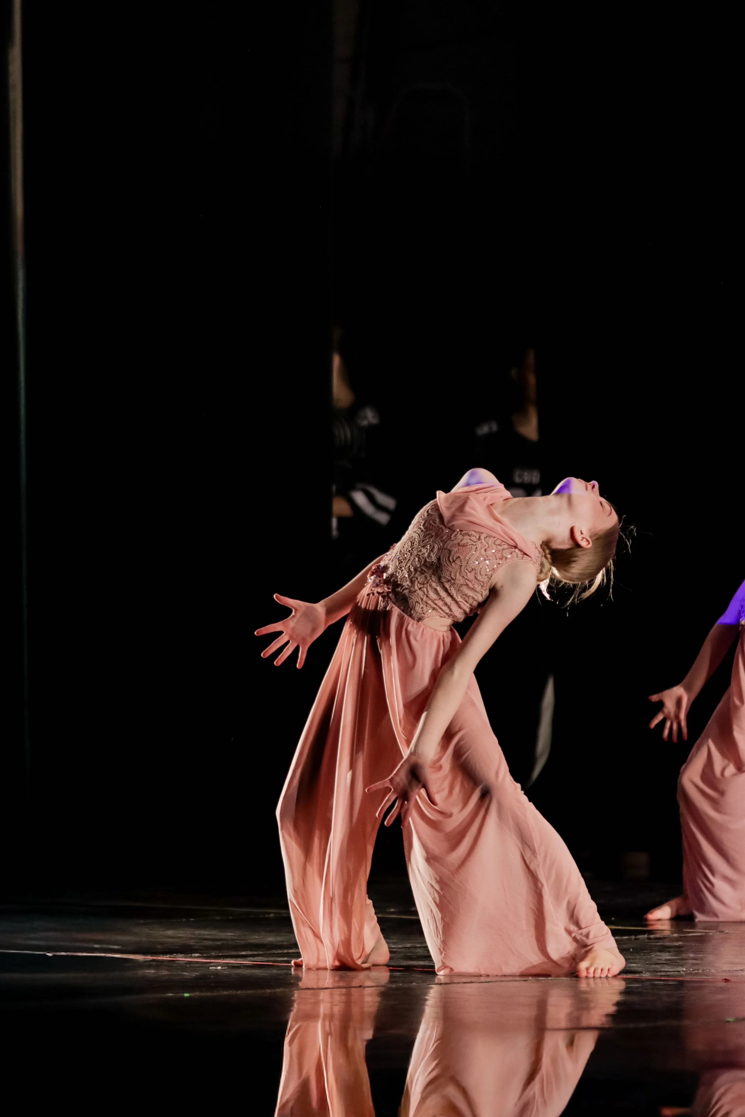 Dramatic photograph of dancer on stage performing contemporary dance