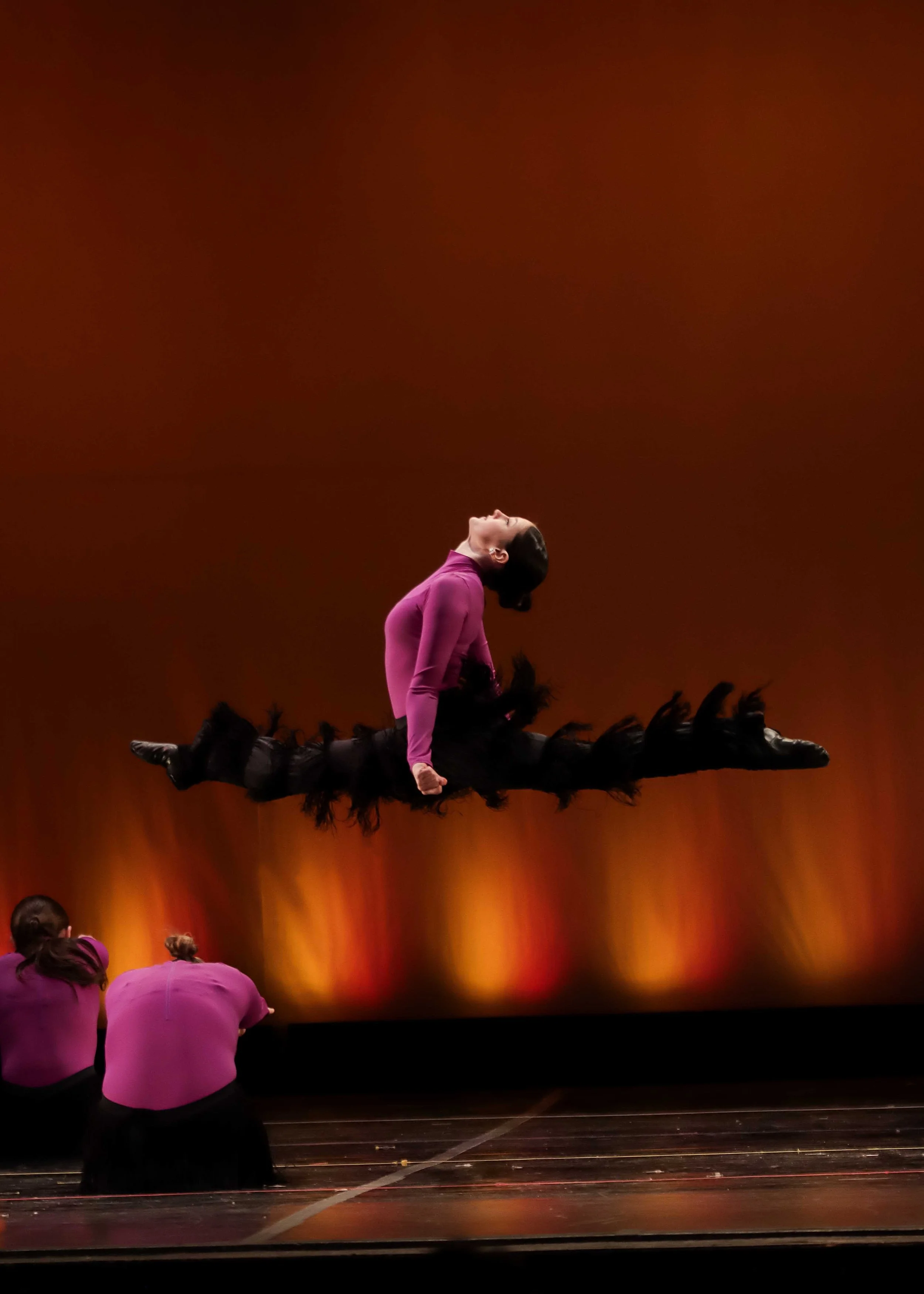 Powerful stage performance capturing extension, movement, and emotion under theatrical lighting