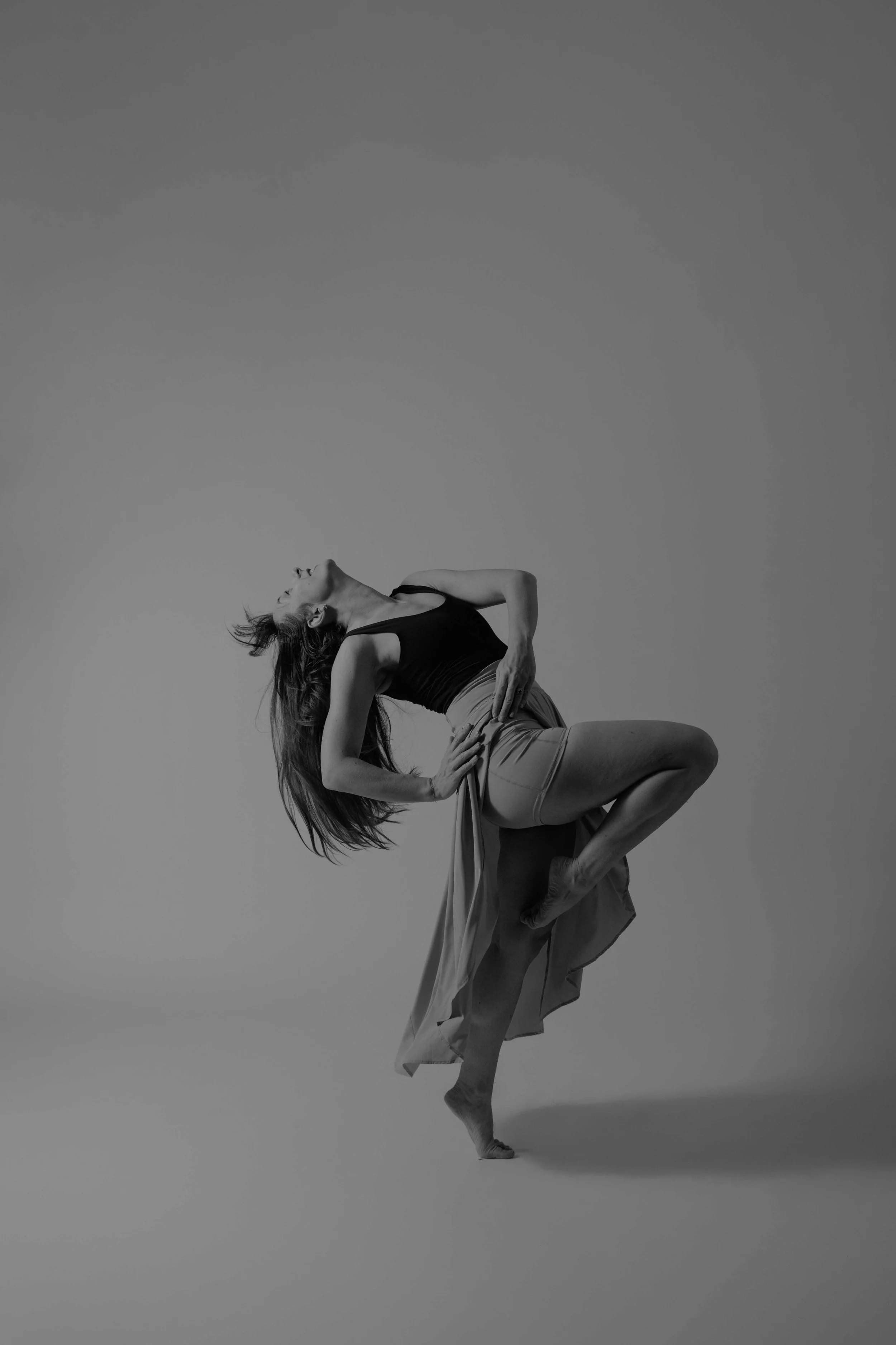 Dancer in a passe pose in a studio setting