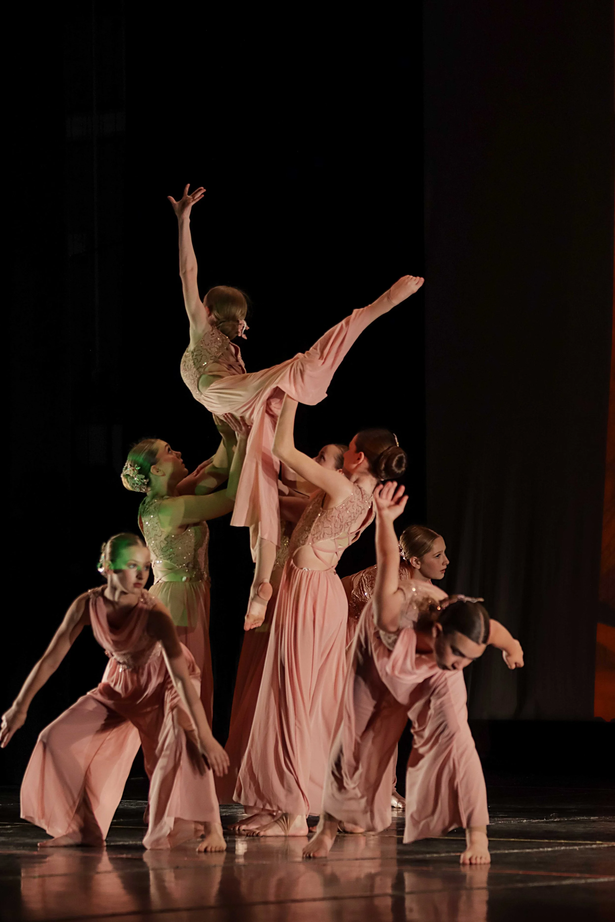 dancers performing a lift during a lyrical dance showcase