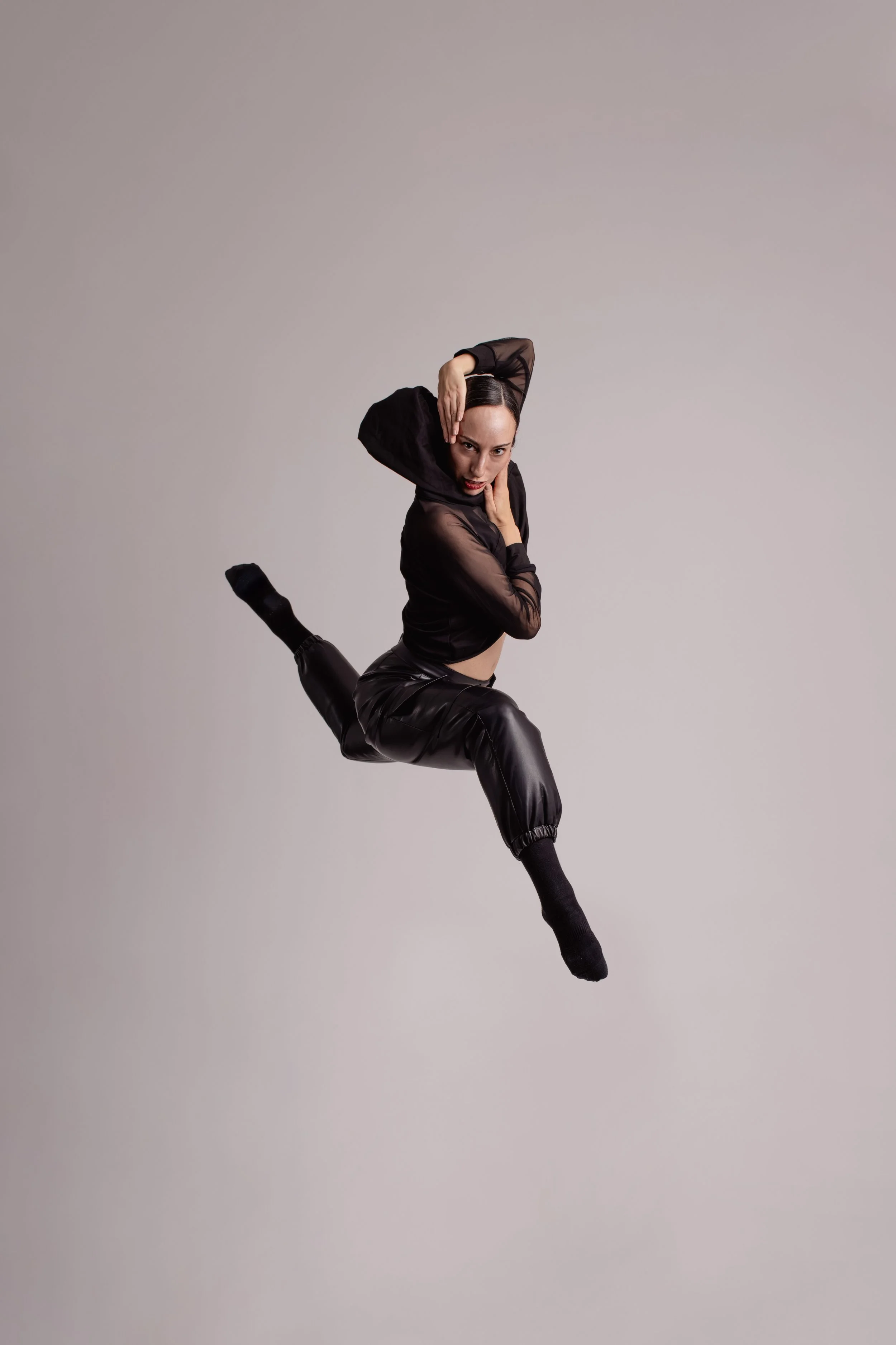 Dancer in a powerful double attitude jump during a photoshoot