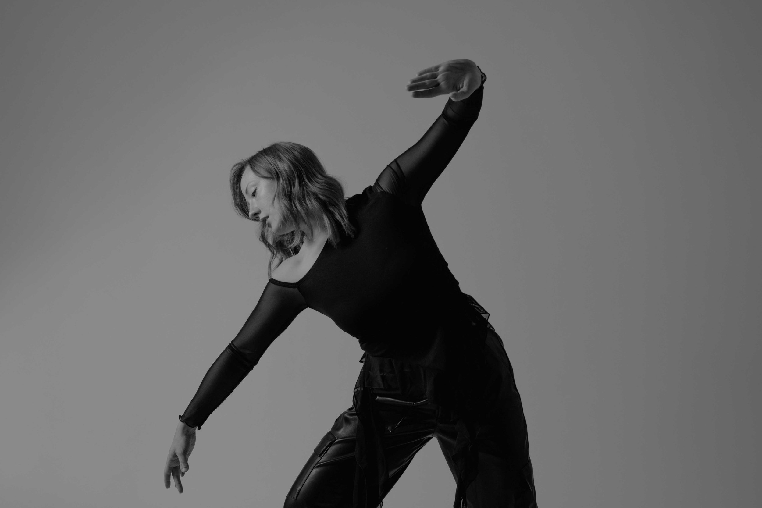 Dancer performing improv contemporary movement in a studio setting