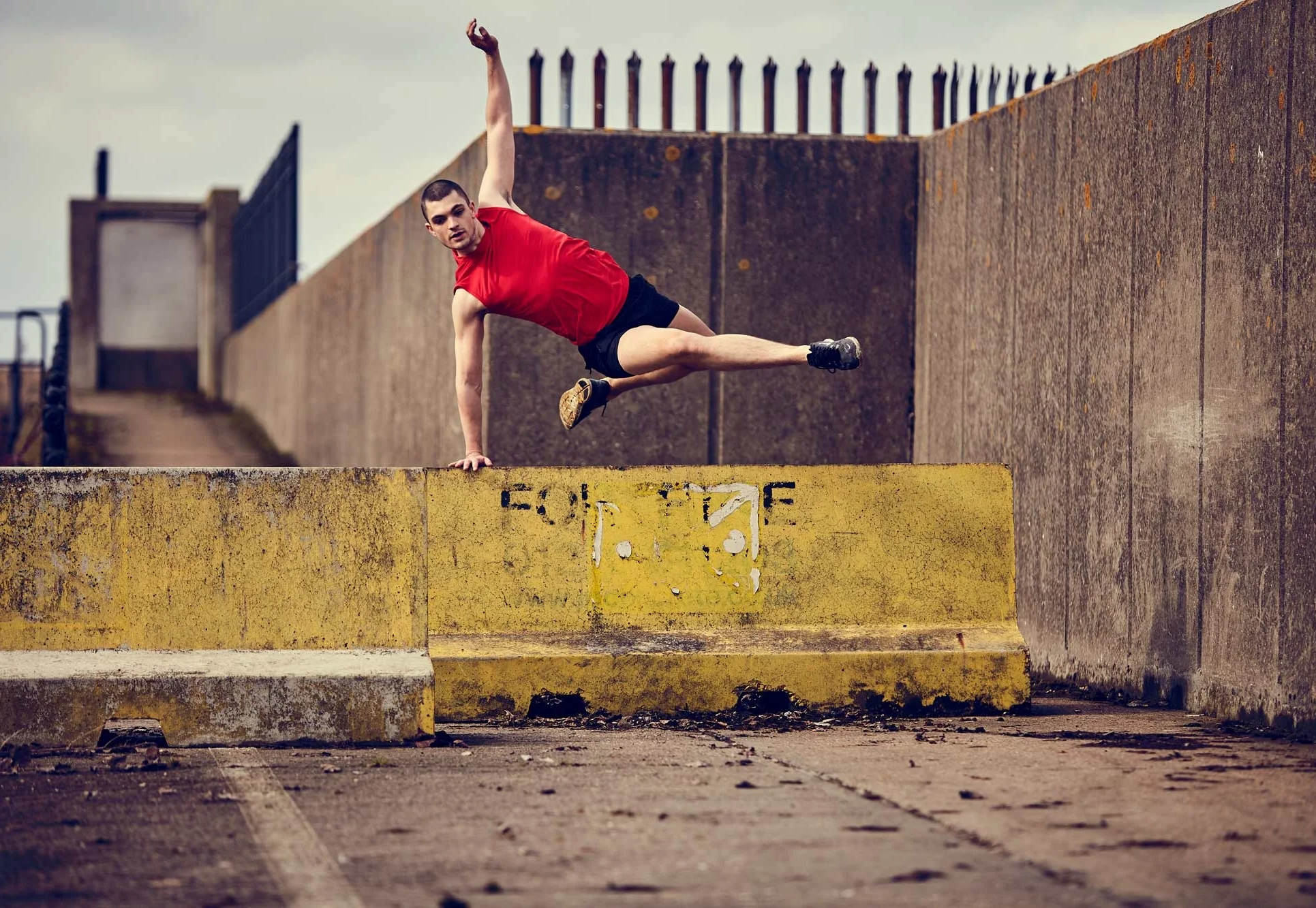 model leaping over a concrete structure for a sports brand