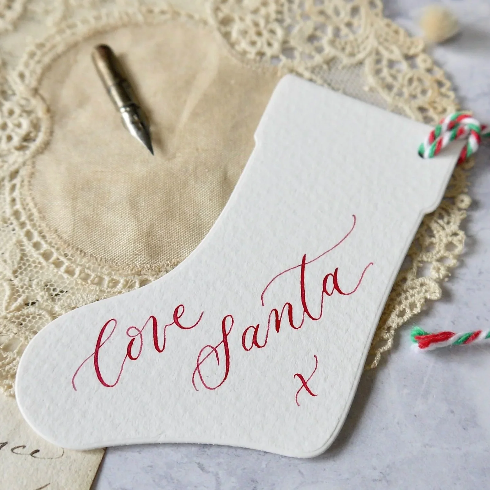 Close-up of modern calligraphy lettering on a personalised Christmas stocking label.
