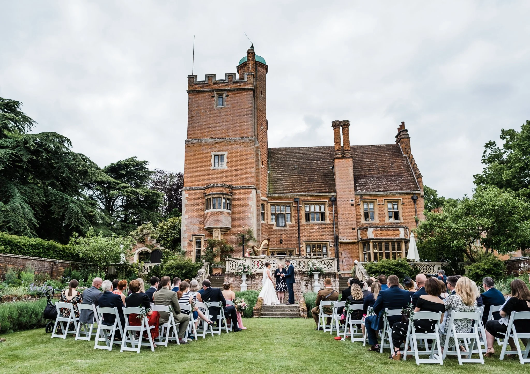 Bride and groom outside Lanwades Hall in Suffolk during their outdoor wedding ceremony